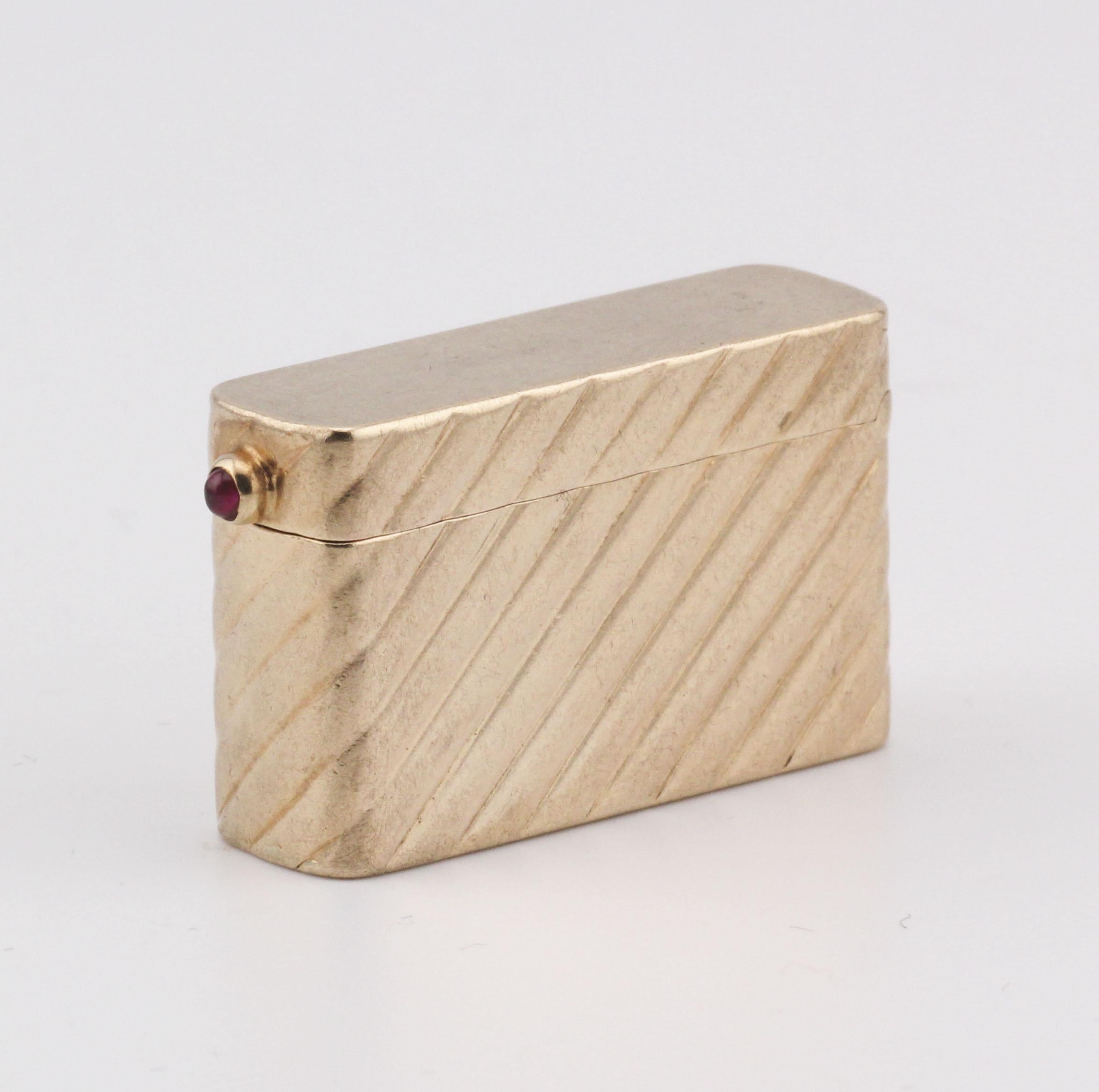 Die Gold Pillbox von Cartier ist ein eindrucksvolles Beispiel für raffinierte Handwerkskunst und luxuriöses Design. Dieses elegante Stück ist aus reichem Gold gefertigt und weist ein unverwechselbares diagonales Streifenmuster auf, das seiner