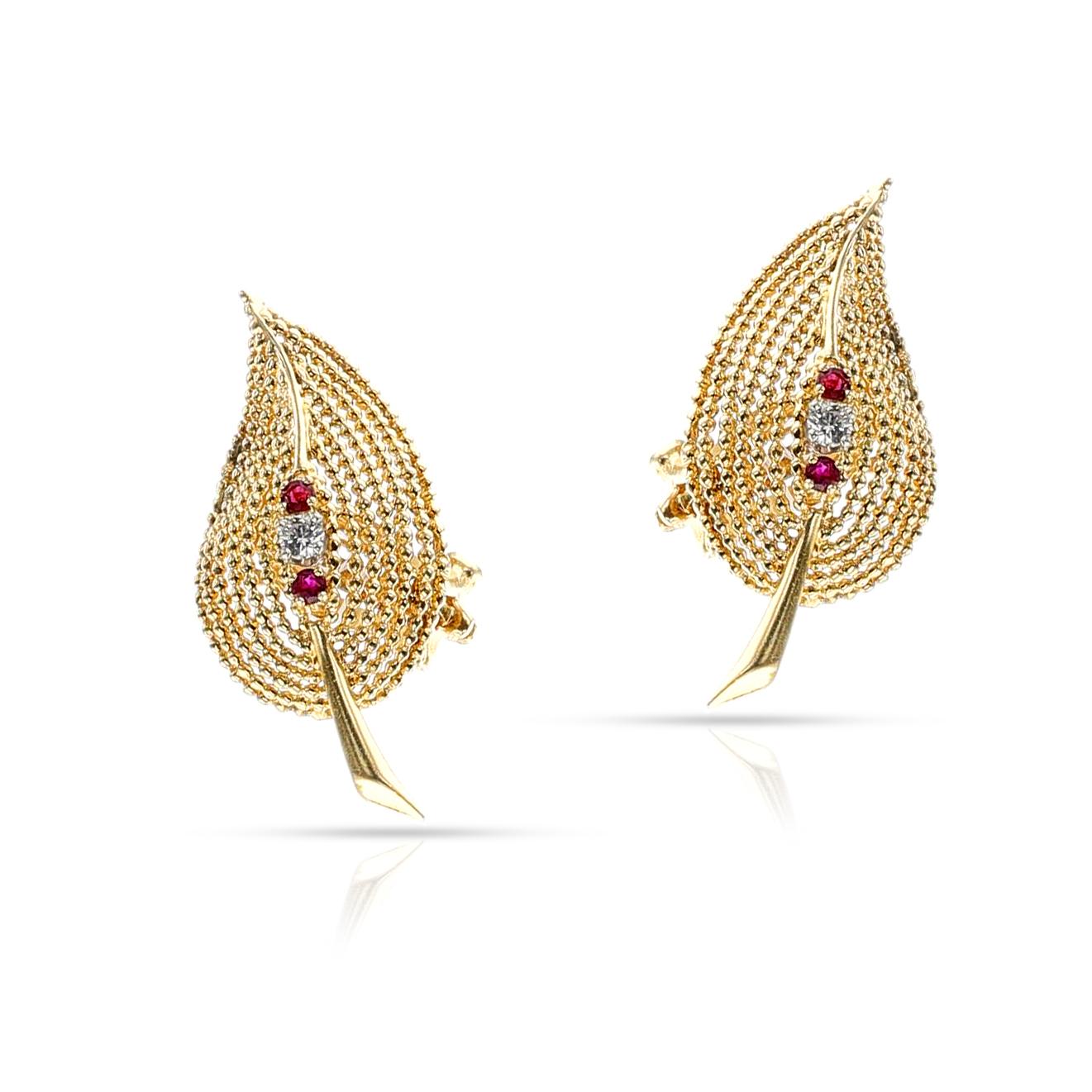   A set of 14k yellow gold Tiffany & Co. Ruby and Diamond Leaf Earrings adorns the ears, an ornate and stylish statement of 7.20 grams in total weight, with a length of 1.4