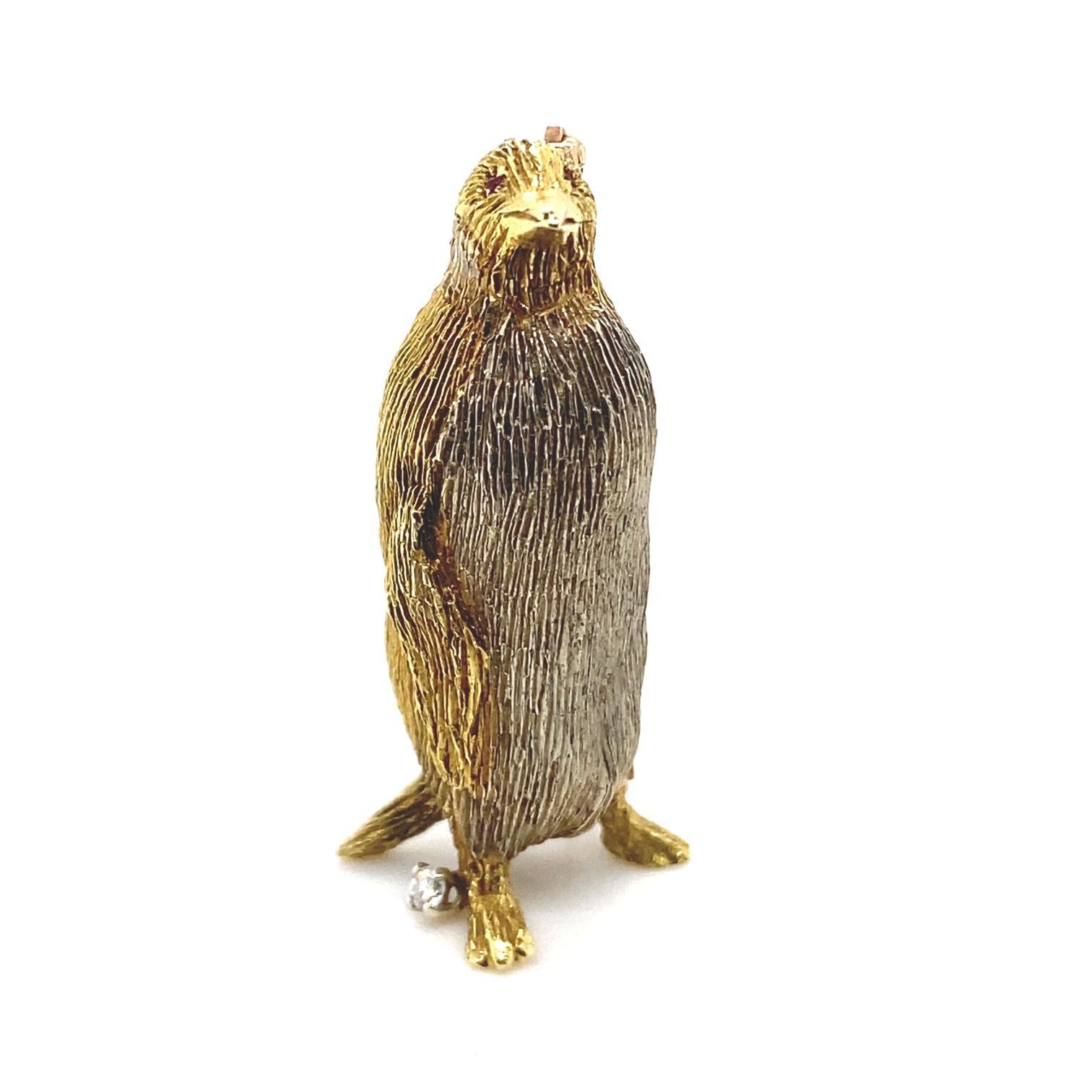 A Tiffany & Co. ruby and diamond penguin brooch in yellow gold, circa 1960.

This charming vintage penguin pin brooch is beautifully made. Its feathers are highly detailed.
He stands next to a round brilliant cut diamond claw set snowball of 0.07cts