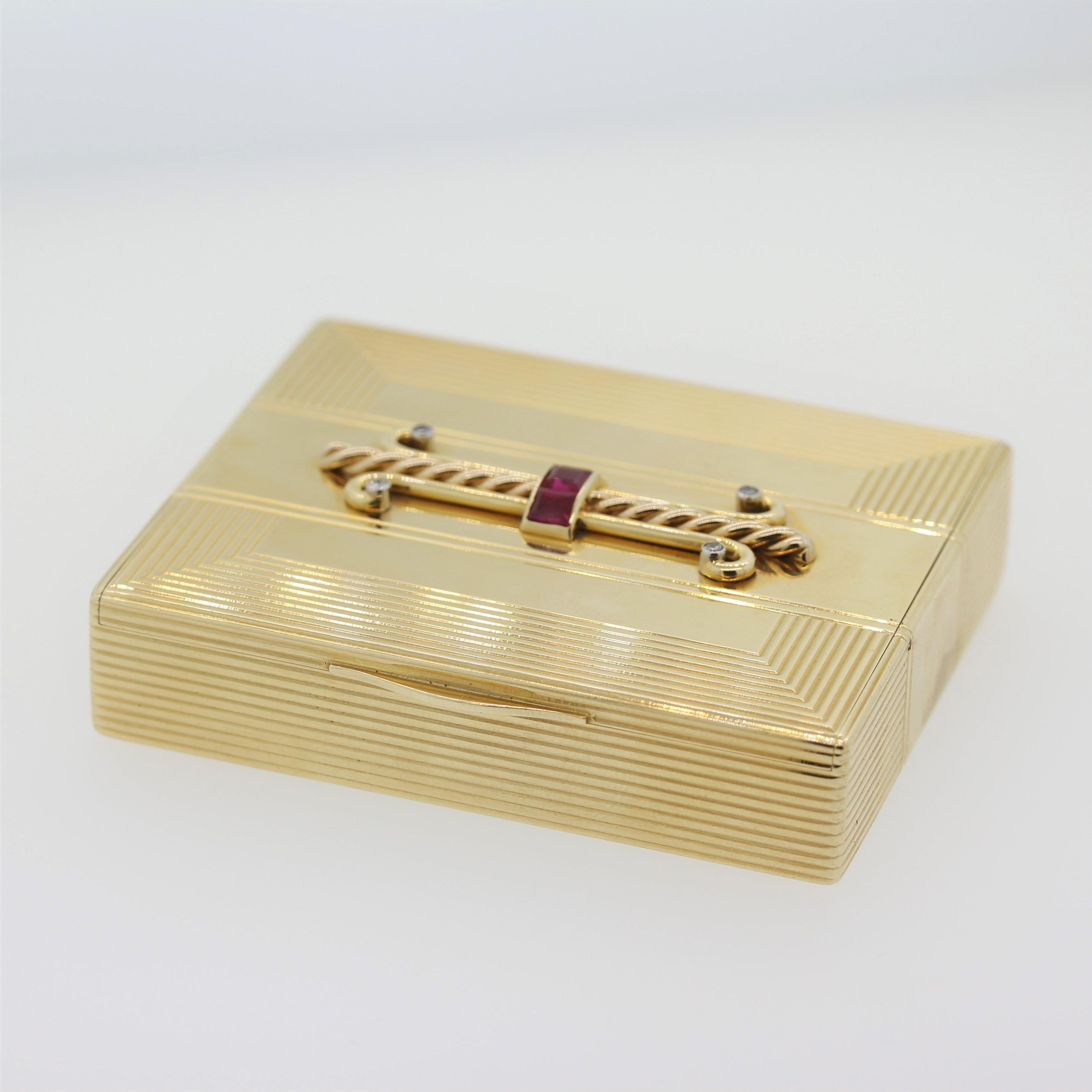 In der Puderdose befinden sich quadratische Rubine im Stufenschliff mit einem Gesamtgewicht von ca. 1,25 Karat, verziert mit Diamanten im Einzelschliff mit einem Gesamtgewicht von 0,15 Karat, gefasst in 14-karätigem Gold, markiert mit Tiffany & Co.
