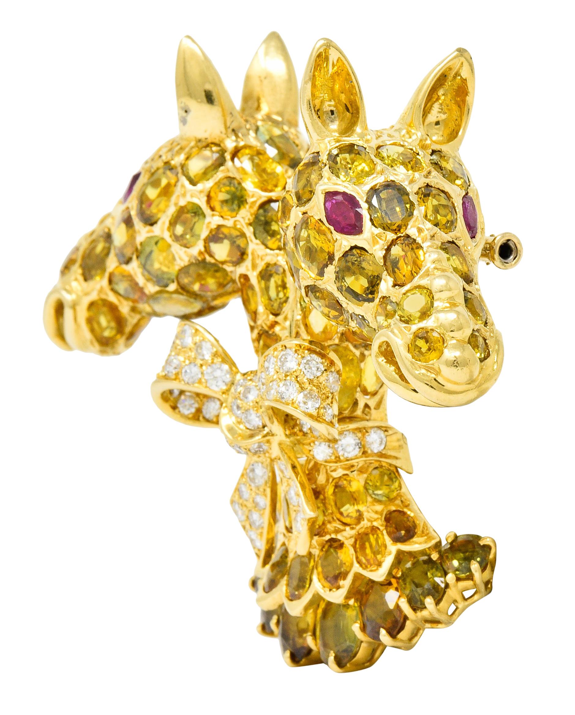 Designed as two mirrored giraffes cinched at the neck with a pavè diamond bow with a beautifully tiered base

Eyes shine bright as well-matched, deeply red, marquise cut rubies weighing approximately 0.88 carat total

Round brilliant cut diamonds