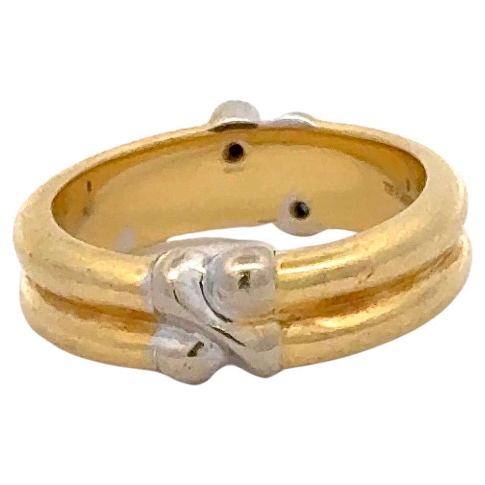Tiffany & Co, banda de oro amarillo de 18 quilates con un diseño en X con dos piedras preciosas, rubí y zafiro, 6,03 gramos.
Puede darse la vuelta para llevarla sin piedras preciosas. 
Talla 4