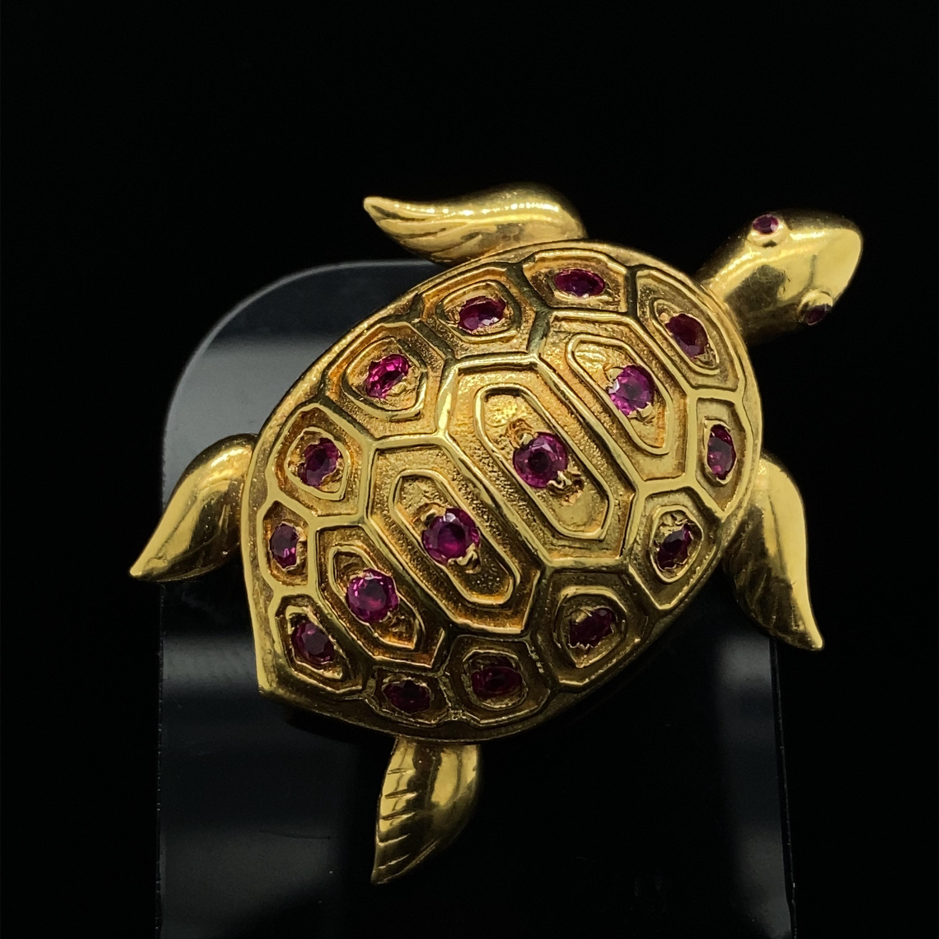 An elegant 18 Karat Yellow Gold turtle brooch crafted by Tiffany & Co, circa 1960.

This vintage turtle pin brooch is highly collectible. Its shell features a hand engraved design grain set with 16 round cut rubies. His legs and arms have a