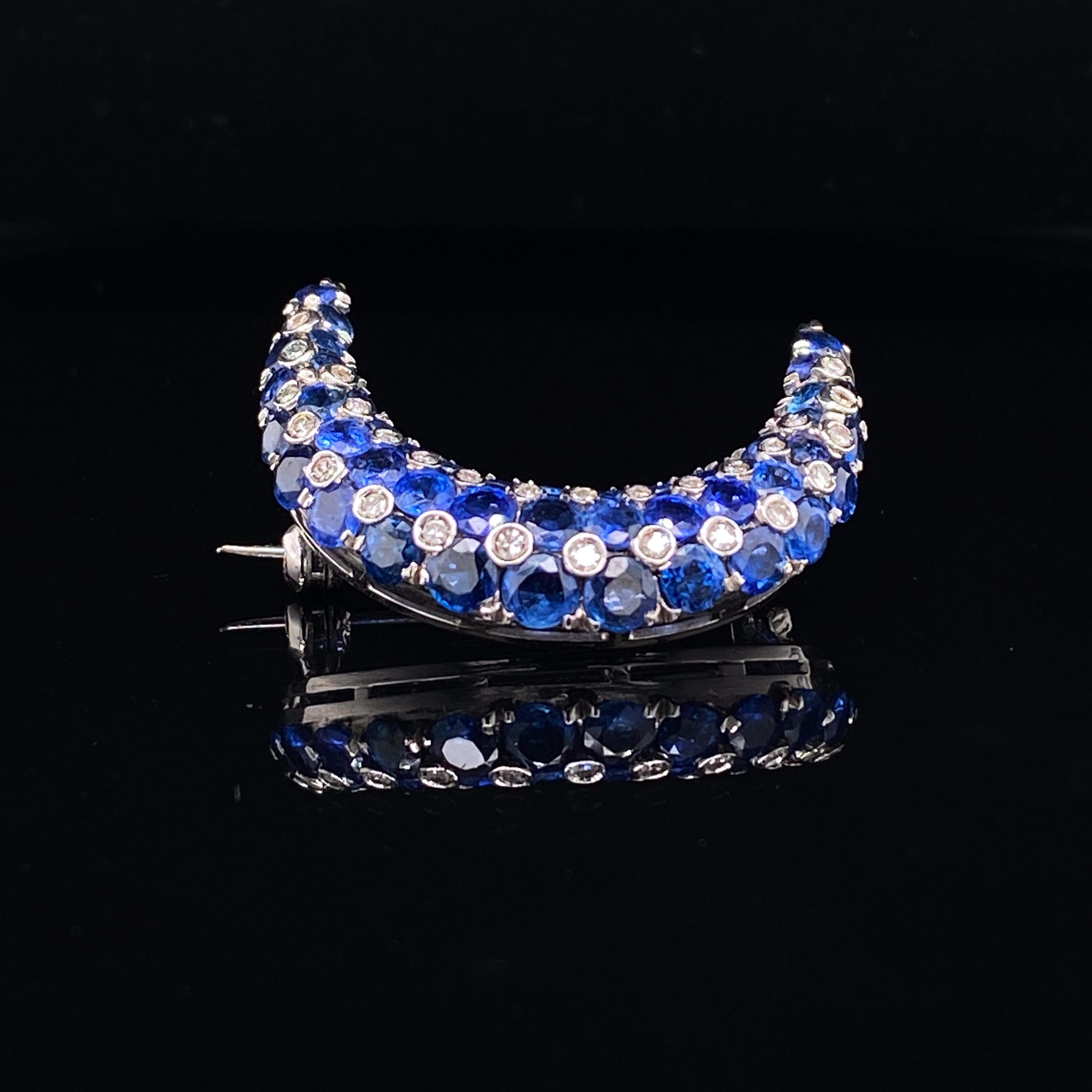 Tiffany & Co sapphire and diamond 18 karat white gold crescent moon brooch circa 1960.

This eye catching retro Tiffany & Co crescent moon shaped brooch is set with excellent mystery set royal blue sapphires and accented by claw set single cut