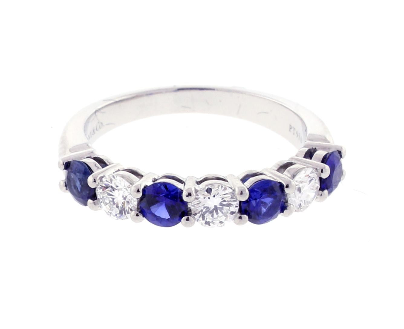 From Tiffany and Co. a sapphire and diamond shared prong band ring.
♦ Designer / Hallmarks: Tiffany & Co
♦ Metal: Platinum
♦ Gem stone: 3 Diamonds = approximately .40 carats  
♦ Gem stone: 4 sapphires =  approximately .60 total carats  
♦ Design