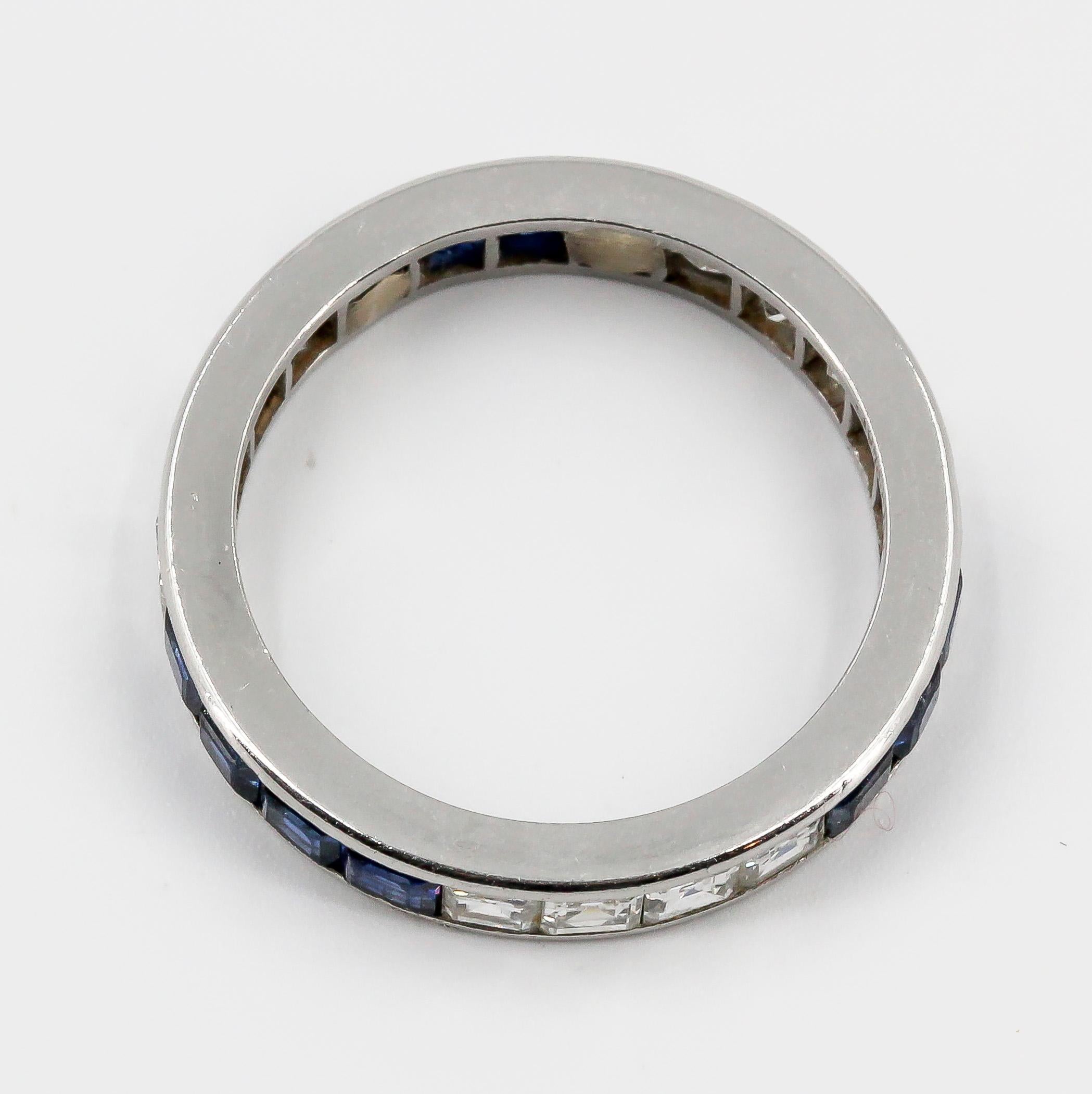 Elegant blue sapphire, diamond and platinum band by Tiffany & Co., Circa 1940s-50s. It features rich blue sapphires and high grade round brilliant cut diamonds. Size 5.75

Hallmarks: Tiffany & Co., Irid. Plat.