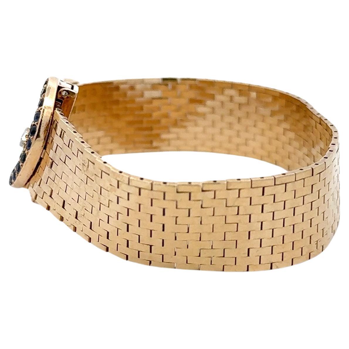 Stamped Tiffany & Co, this woven bracelet features a Sapphire and diamond closure buckle motif weighing 42.1 grams, 14 karat yellow gold. 