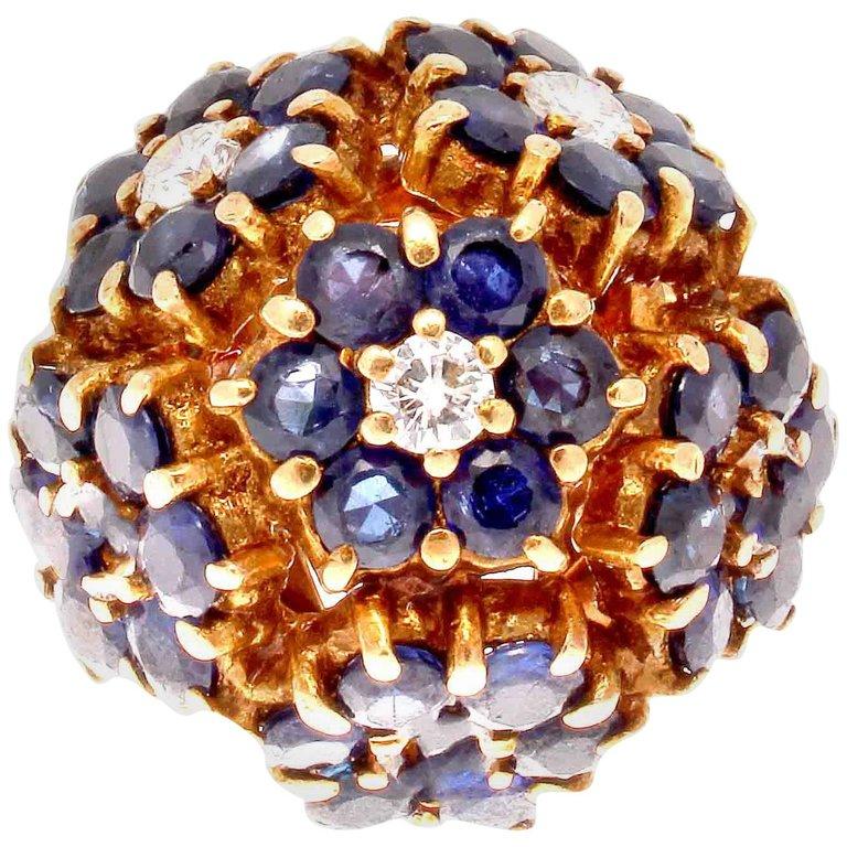 Tiffany & Co. is known for exquisite floral jewelry, and this ring is no exception. The blossoming bouquet of flowers features vibrant navy blue sapphires that are perfectly finished by round cut colorless diamonds. Meticulously hand crafted in 18k