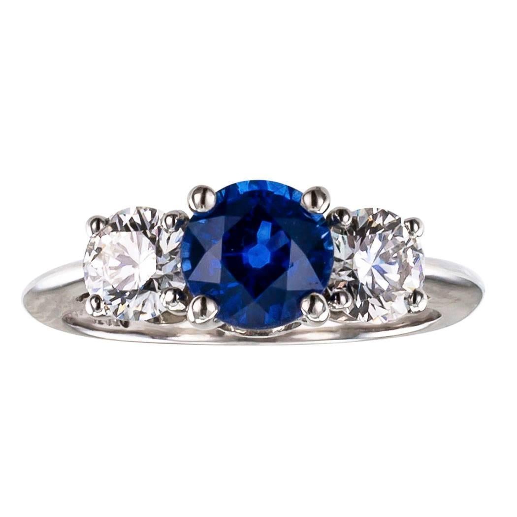 Tiffany & Co sapphire and diamond three stone platinum engagement ring.  Centering upon a vibrant round blue sapphire weighing approximately 1.14 carats, between a pair of round brilliant-cut diamonds totaling approximately 0.73 carat, approximately