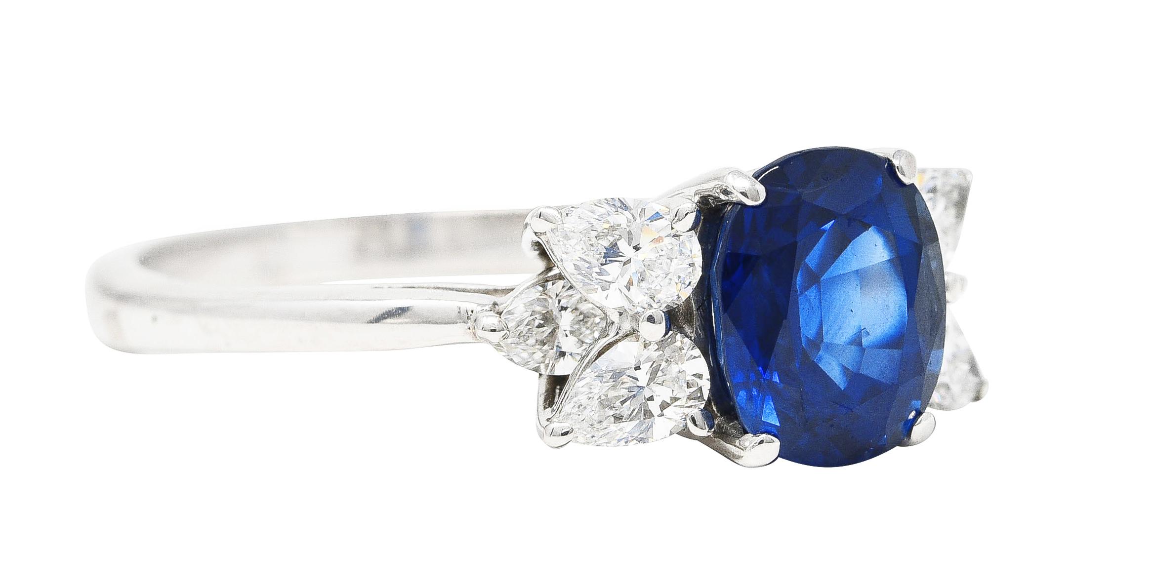 Centering an oval cut sapphire weighing approximately 2.60 carats total - transparent medium to deep  blue in color. Prong set and flanked by pear and marquise cut diamonds prong set in tiered cathedral shoulders. Weighing approximately 0.74 carat