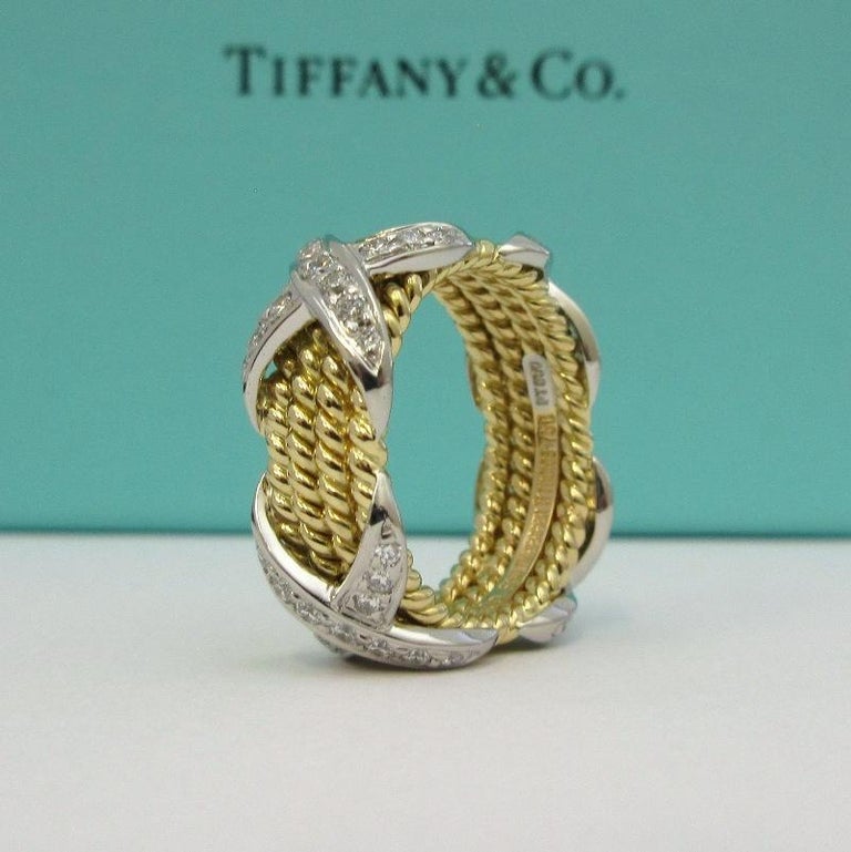 TIFFANY & Co. Schlumberger 18K Gold Platinum Diamond Rope Four-row X Ring 5.5

Metal: 18K gold and platinum
Size: 5.5
Width: 8.6mm at the widest point
Weight: 11.80 grams 
Diamond: round brilliant diamonds, carat total weight .54 
Hallmark: