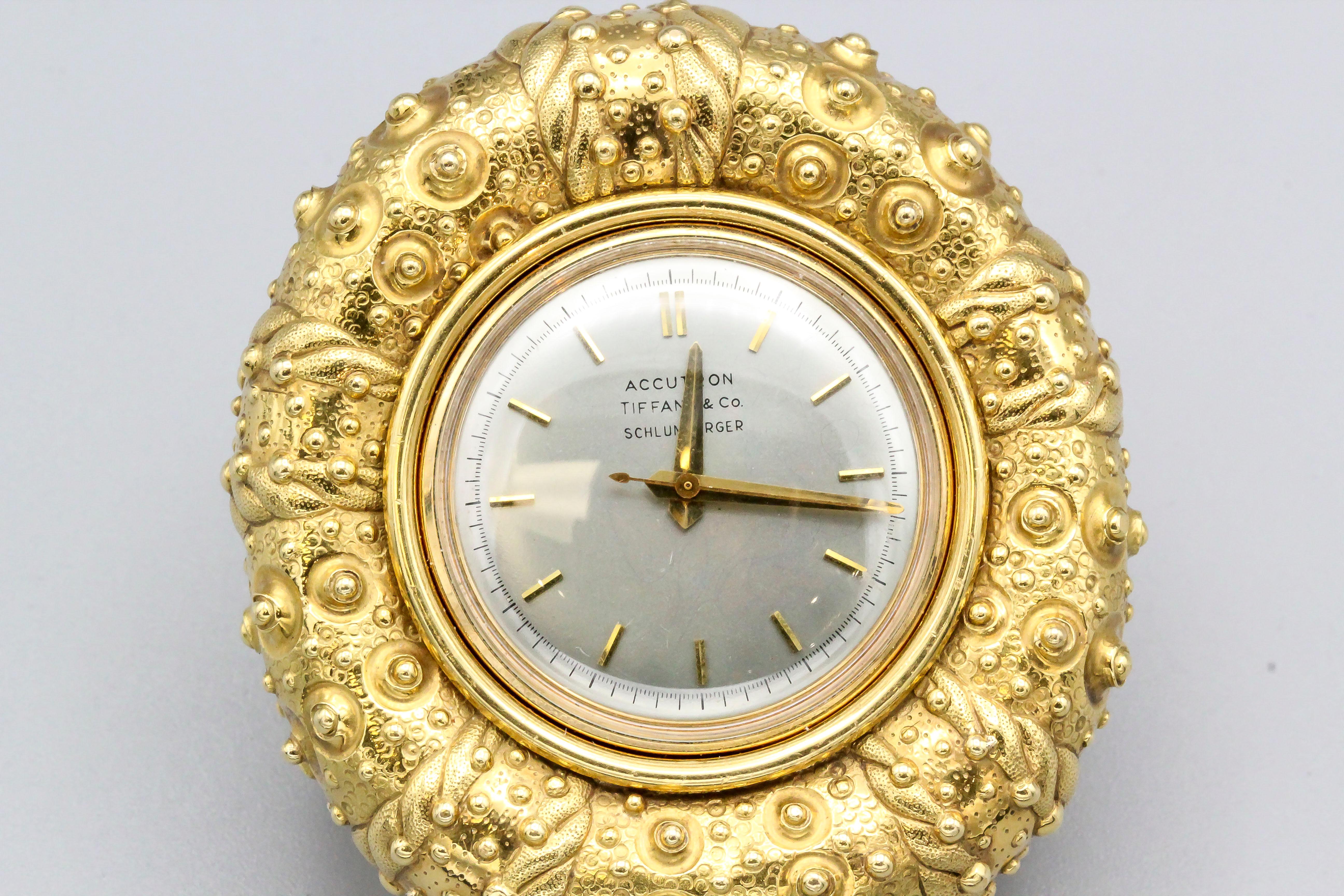 Elegant 18K yellow gold clock by Tiffany & Co. Schlumberger. It resembles a sea urchin. Bulova Accutron movement in excellent working condition.

Hallmarks: Tiffany & Co., Schlumberger, Bulova Accutron. Back of clock: Bulova, 18KT Gold, patented,