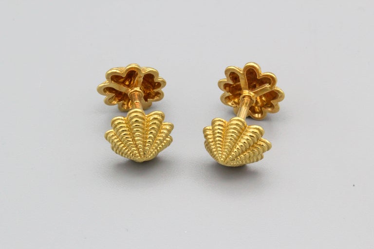 Fine pair of 18K yellow gold cufflinks by Tiffany & Co. Schlumberger, circa 1990s.  The cufflinks have a shell-like shape at each end, with excellent attention to detail, and a short rod connector to keep the shirt cuff in place.

Hallmarks: Tiffany