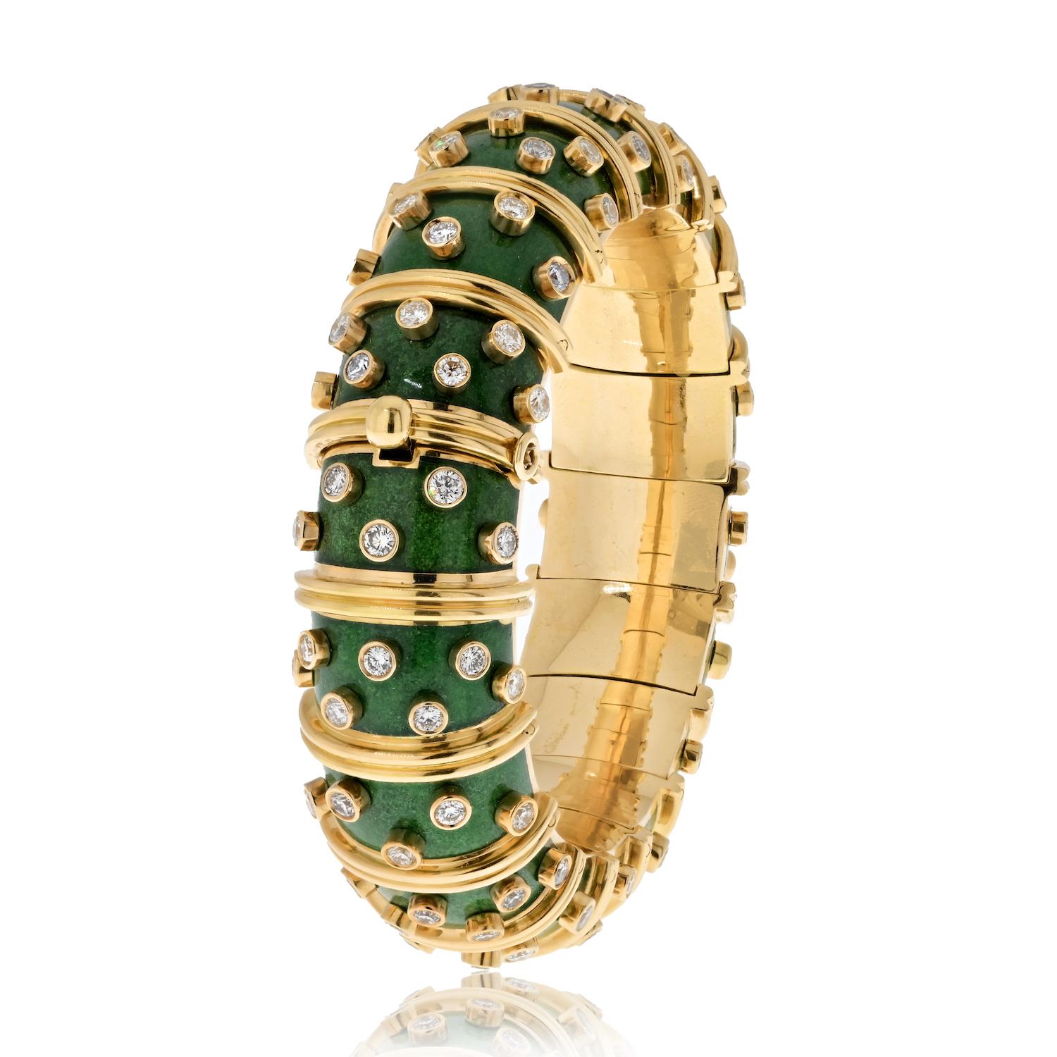 Behold this exquisite creation, a green paillonne enamel hinged bangle that encapsulates the brilliance of design and craftsmanship. This bangle is adorned with collet-set diamonds, each sparkling with its unique radiance, while sculpted 18k gold
