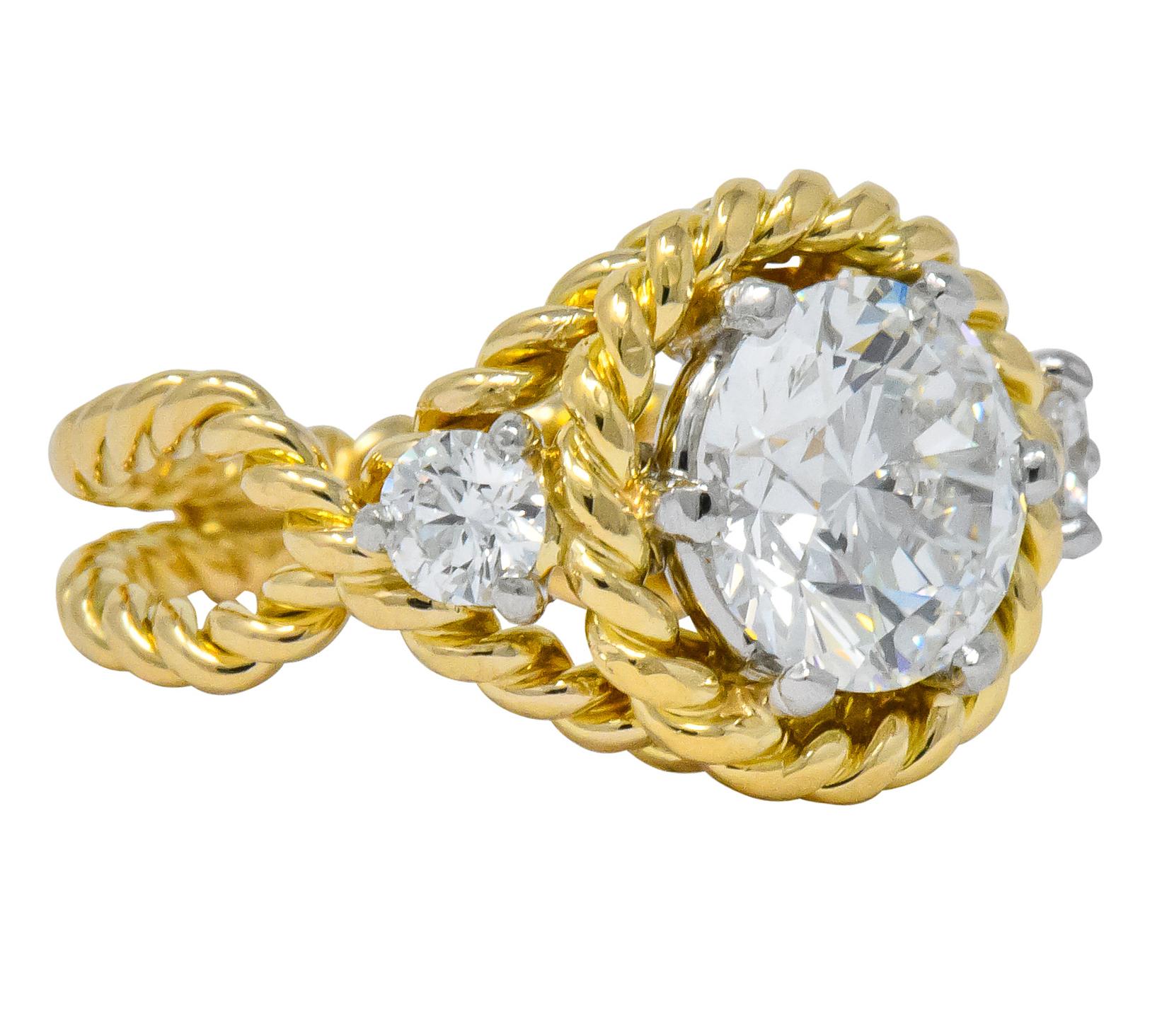 Centering a round brilliant cut diamond weighing 2.20 carats, F color and SI1 clarity

Flanked by a round brilliant cut diamond on each side, weighing approximately 0.30 carat total, F color and VS clarity

The center features twisted rope surround