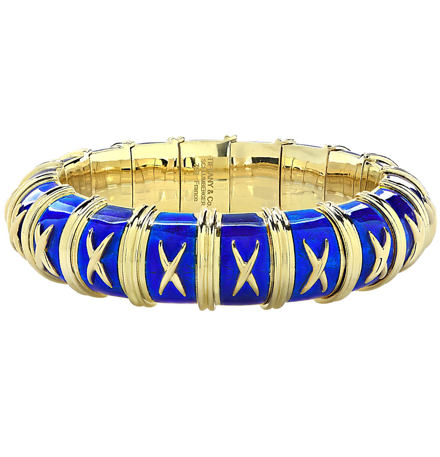 Stunning Tiffany And Co Schlumberger bangle from the crossillion collection, crafted in 18k yellow gold and enriched with Vibrant royal blue enamel, accented with gold X’s and double piped borders surrounding the entire bracelet. The bracelet