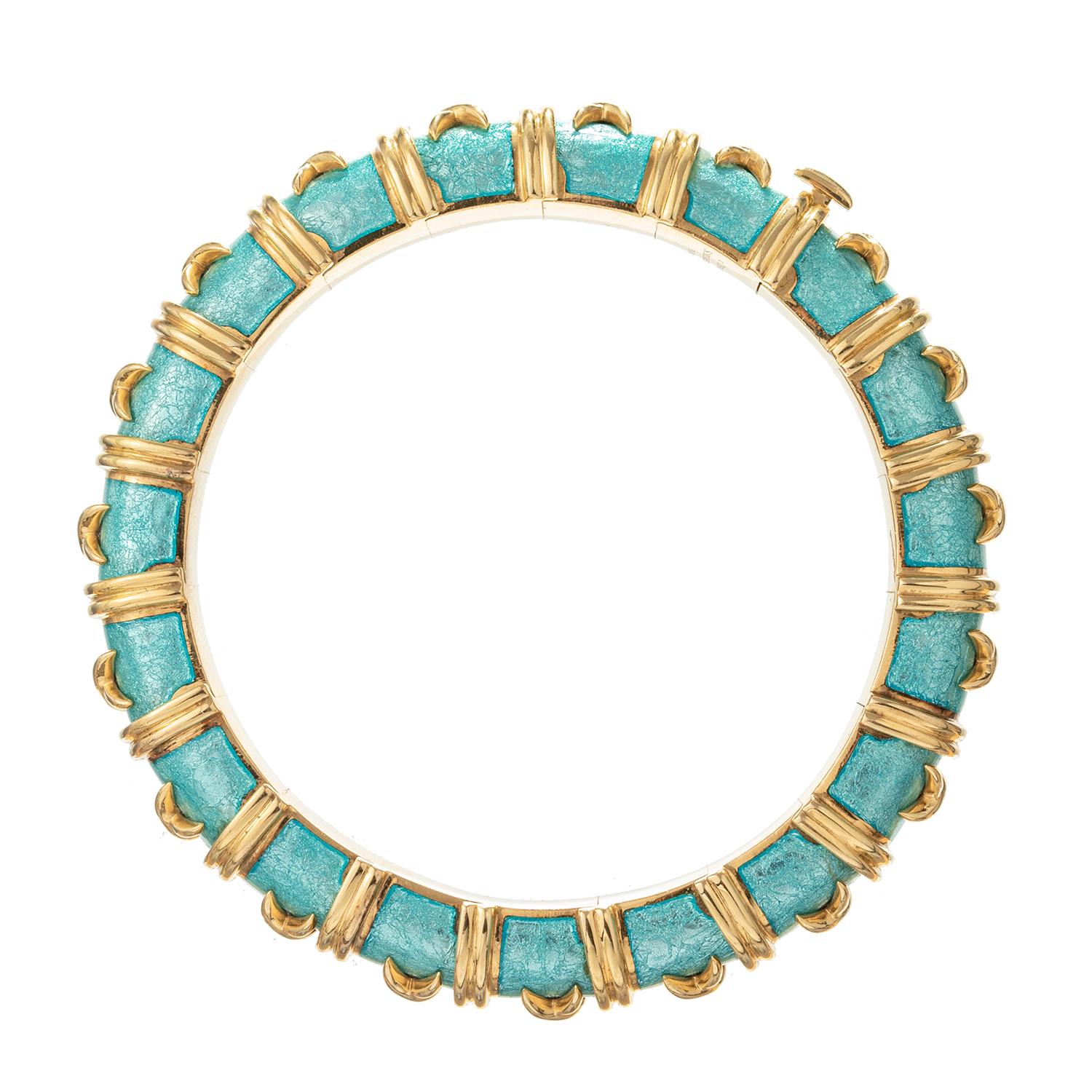 A timeless 18 karat yellow gold and azure enamel 'Croisillon' bracelet designed by Schlumberger for Tiffany & Co.  The finely articulated azure paillonné enamel bangle has applied cross-shaped gold details with reeded band spacers.  Inner