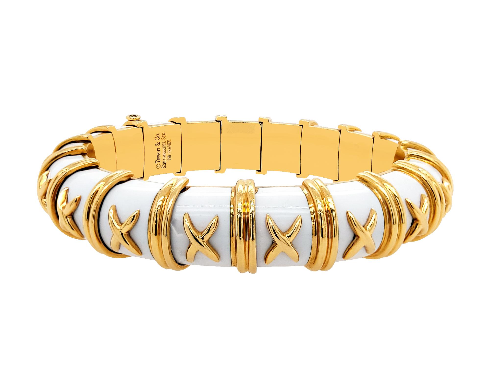 A classy cuff bracelet made in 18k yellow gold and white enamel from the famous Schlumberger Croisillon collection for Tiffany & Co.
The bracelet is decorated with a golden ''X'' on each link all over the bangle. 
The weight of the bracelet is 91.71