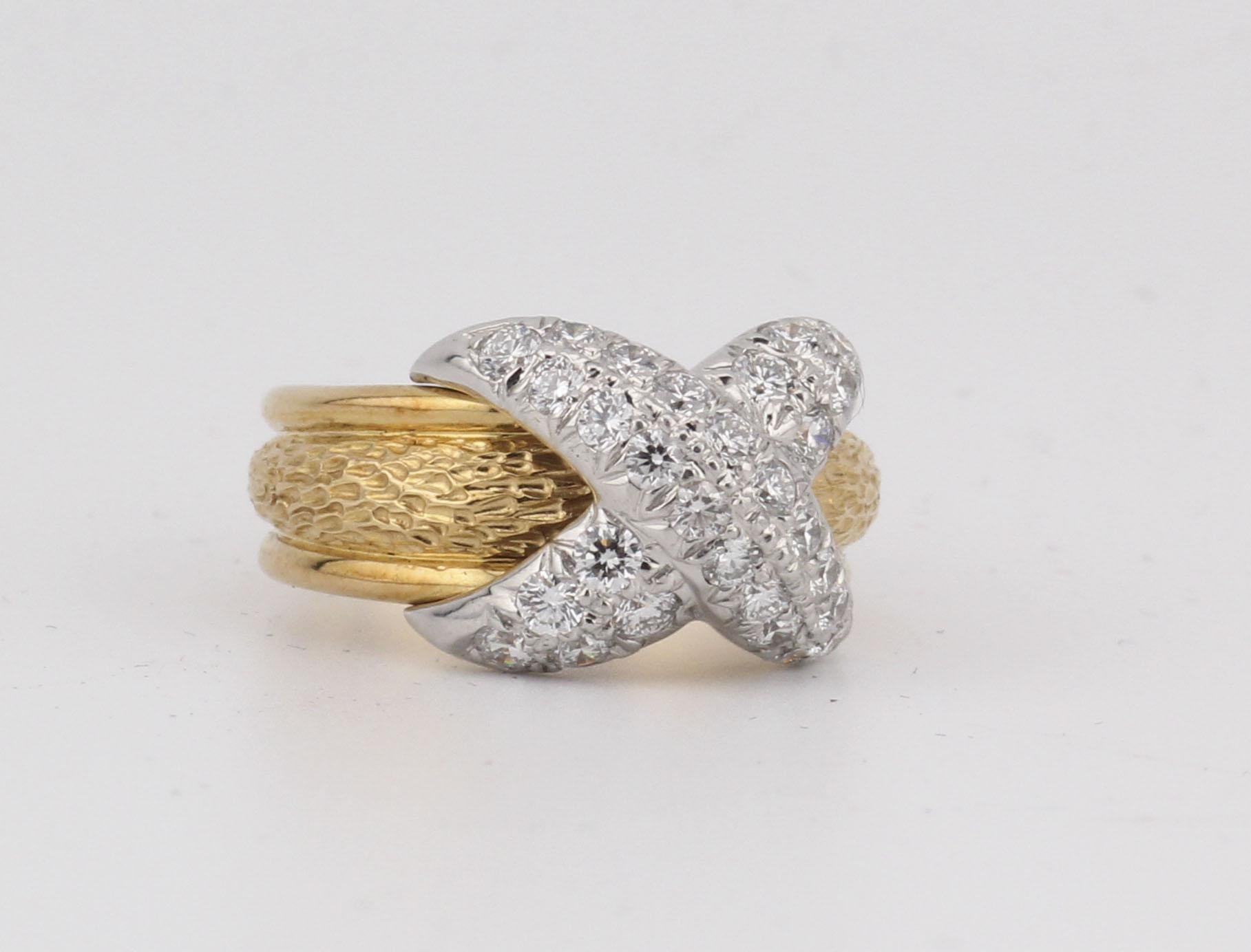 The Tiffany & Co. Schlumberger 18K Yellow Gold Ring with Platinum X Design and Two Rows of Brilliant Diamonds is a striking masterpiece that embodies the luxurious artistry of Jean Schlumberger for Tiffany & Co. This elegant ring features two rows