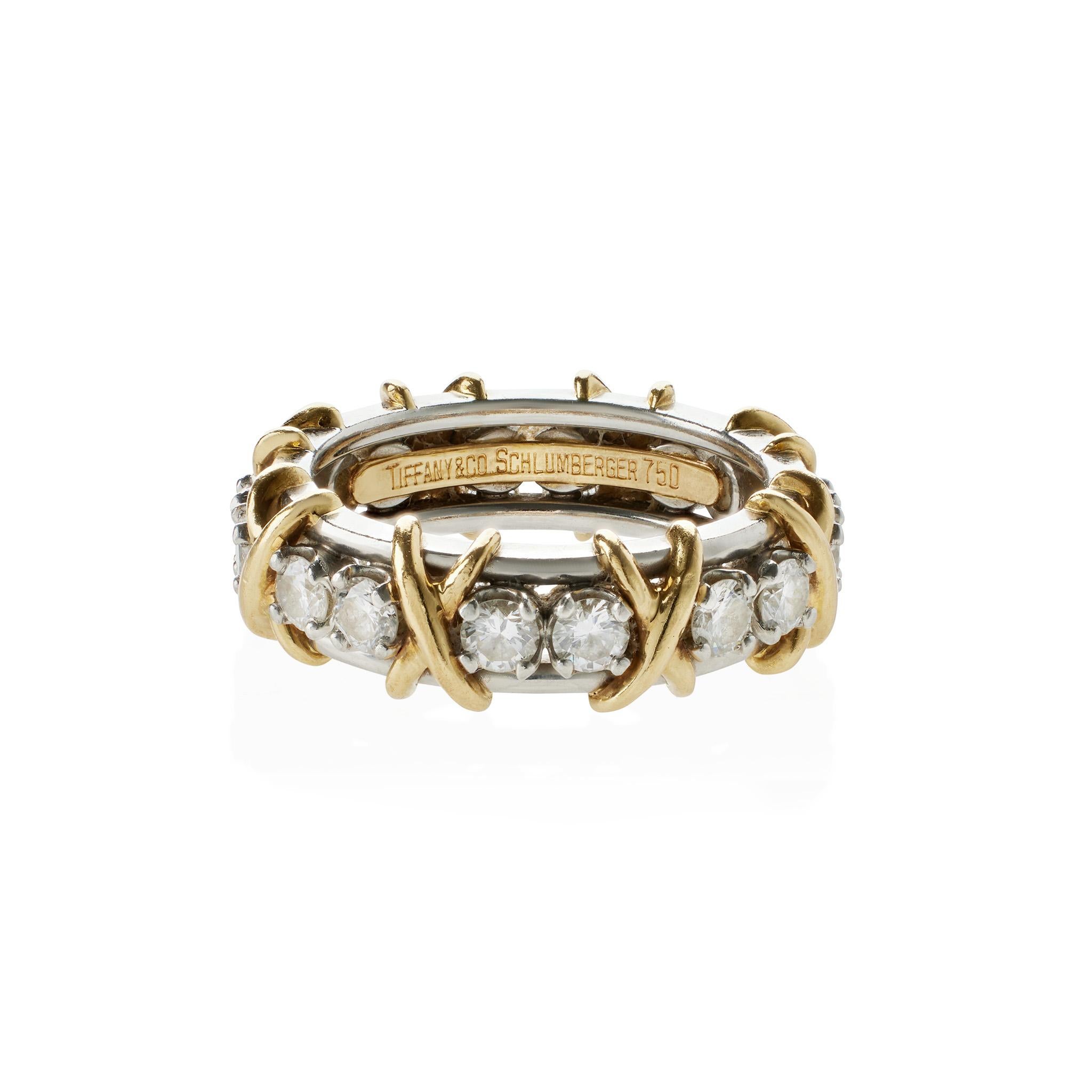 This Tiffany & Co. bi-color 18K gold diamond Sixteen Stone Ring was designed by Jean Schlumberger dates from the late 20th century. The ring is set with pairs of round brilliant-cut diamonds interspersed with yellow gold X motifs joining double