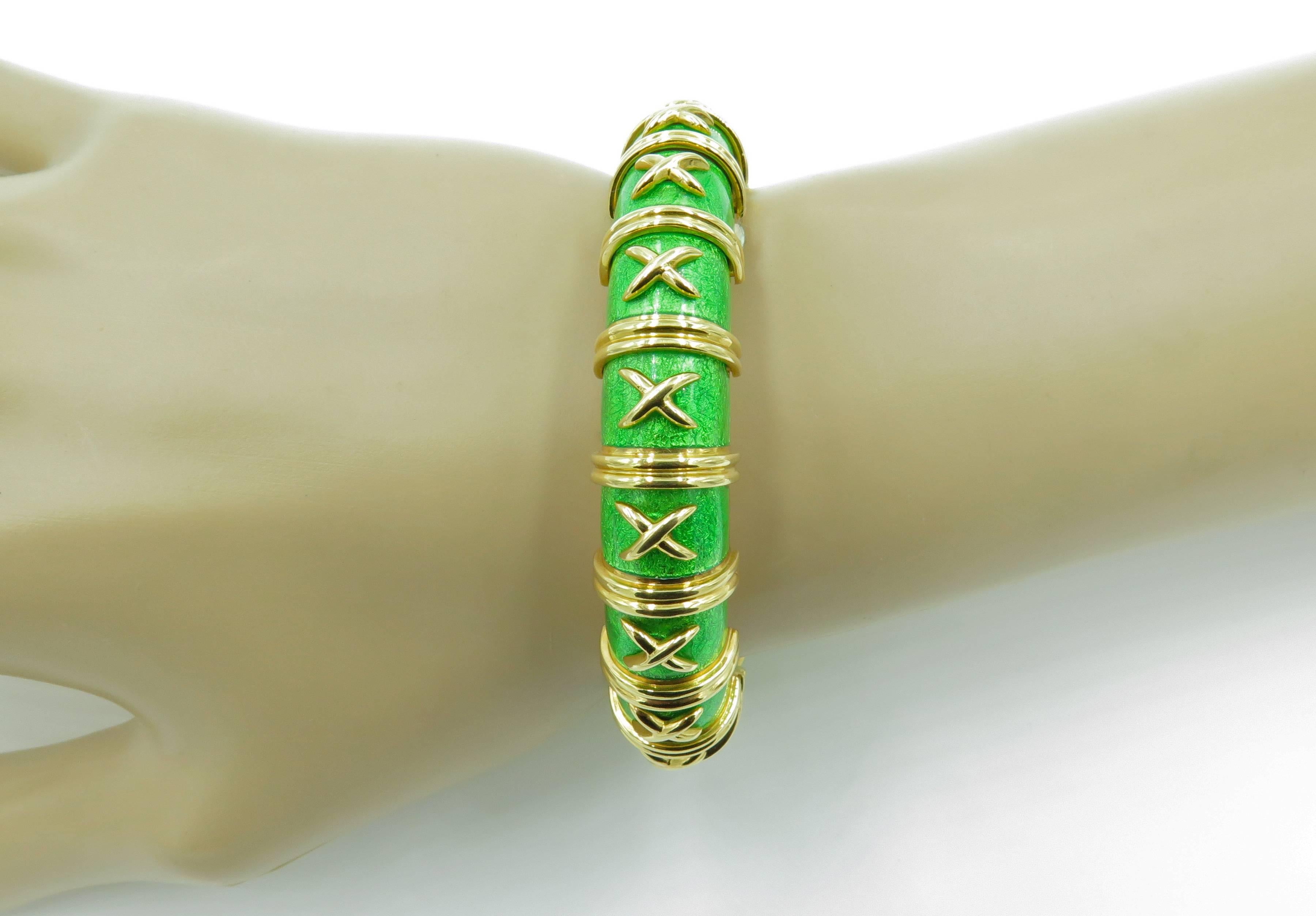 An 18 karat yellow gold and green enamel bracelet.  Signed Tiffany & Co Schlumberger.  Made in France.  The model is known as Croisillon Bracelet. The kelly green paillonné enamel articulated bracelet with applied cross-shaped gold details and