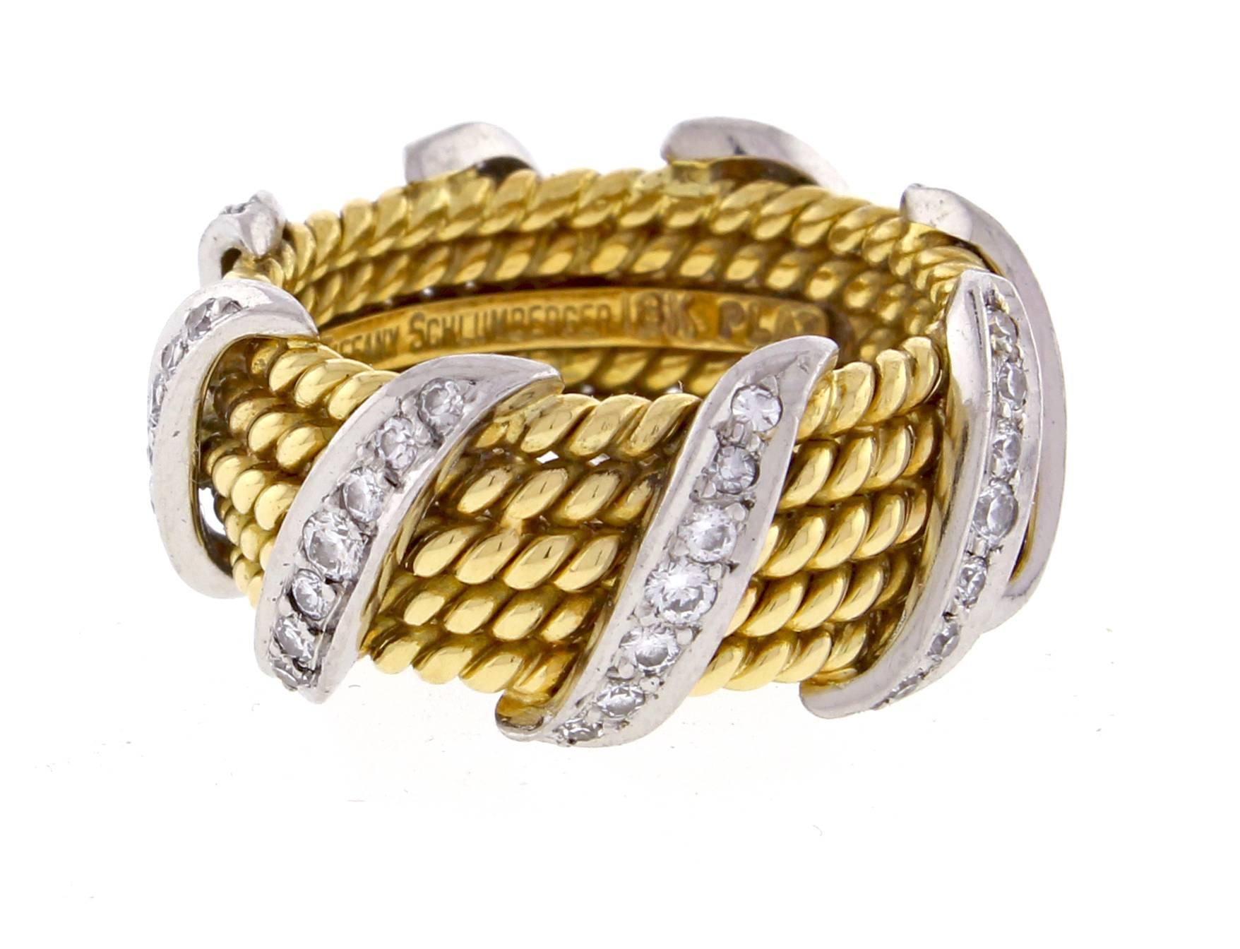  From Jean Schlumberger for Tiffany & Co. a wide band ring. Designed with five 18 karat yellow gold twisted ropes and accented by brilliant diamonds set in a diagonal wrap bands in platinum, signed Schlumberger for Tiffany & Co. 56 diamonds weighing