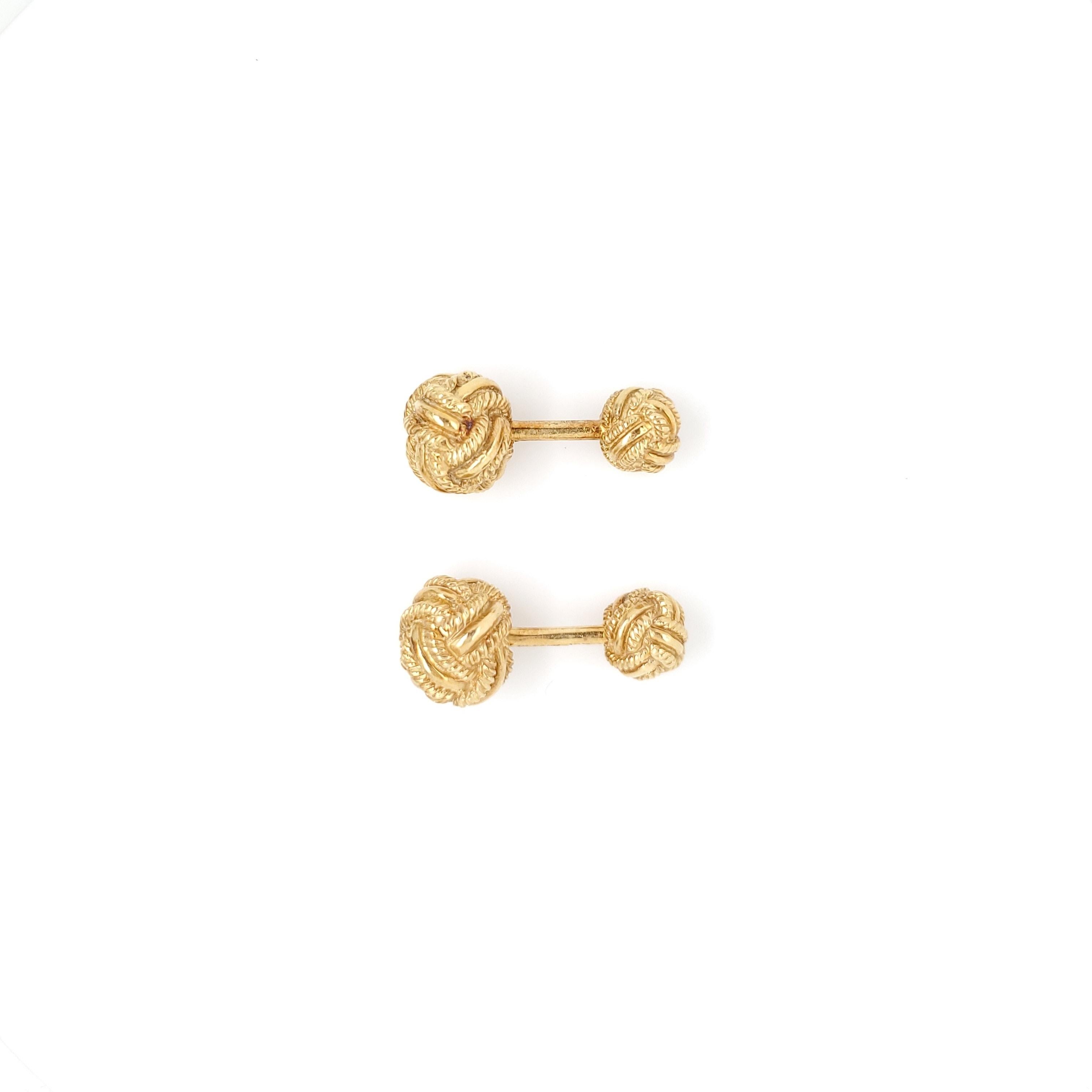 A pair of 18 karat yellow gold woven knot cufflinks made by Jean Schlumberger for Tiffany & Co. The larger knot measures 11mm in diameter and the smaller knot at 8mm. Each cufflink measures 25mm in length. Both are signed Tiffany, 18 and