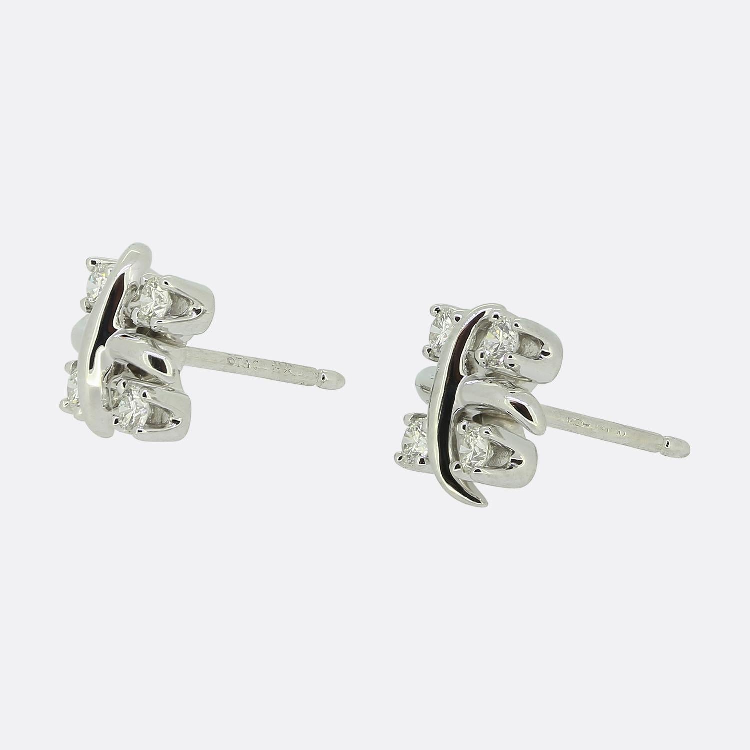 Here we have a stylish pair of diamond earrings from the world renowned jewellery designer, Tiffany & Co. Each piece has been crafted from platinum into the iconic Schlumberger 'X' design with four claw set round brilliant cut diamonds for company.
