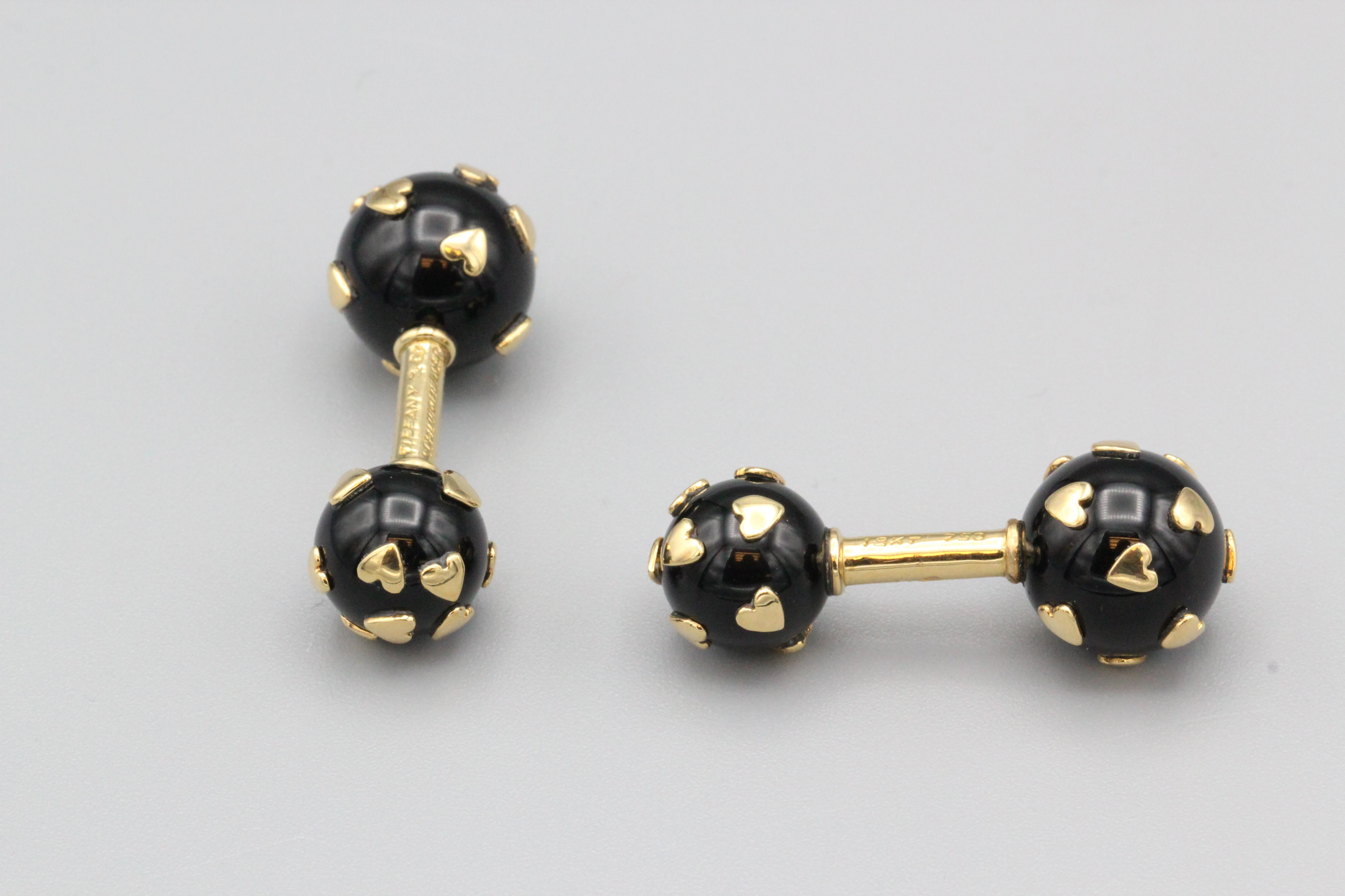 Fine pair of 18K yellow gold and onyx dumbbell cufflinks by Tiffany & Co. Schlumberger.  These cufflinks are made of fine polished onyx spheres that are studded with 18k gold heart shaped beads interspersed on each end.  Of very fine quality and