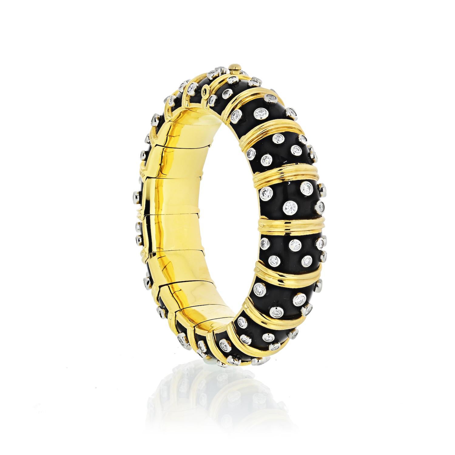 AN ENAMEL AND DIAMOND BANGLE BRACELET, BY JEAN SCHLUMBERGER, TIFFANY & CO.
18 kt., the articulated link bombe bangle applied with black paillonne enamel, alternately spaced by ribbed gold bands, studded with 108 collet-set round diamonds