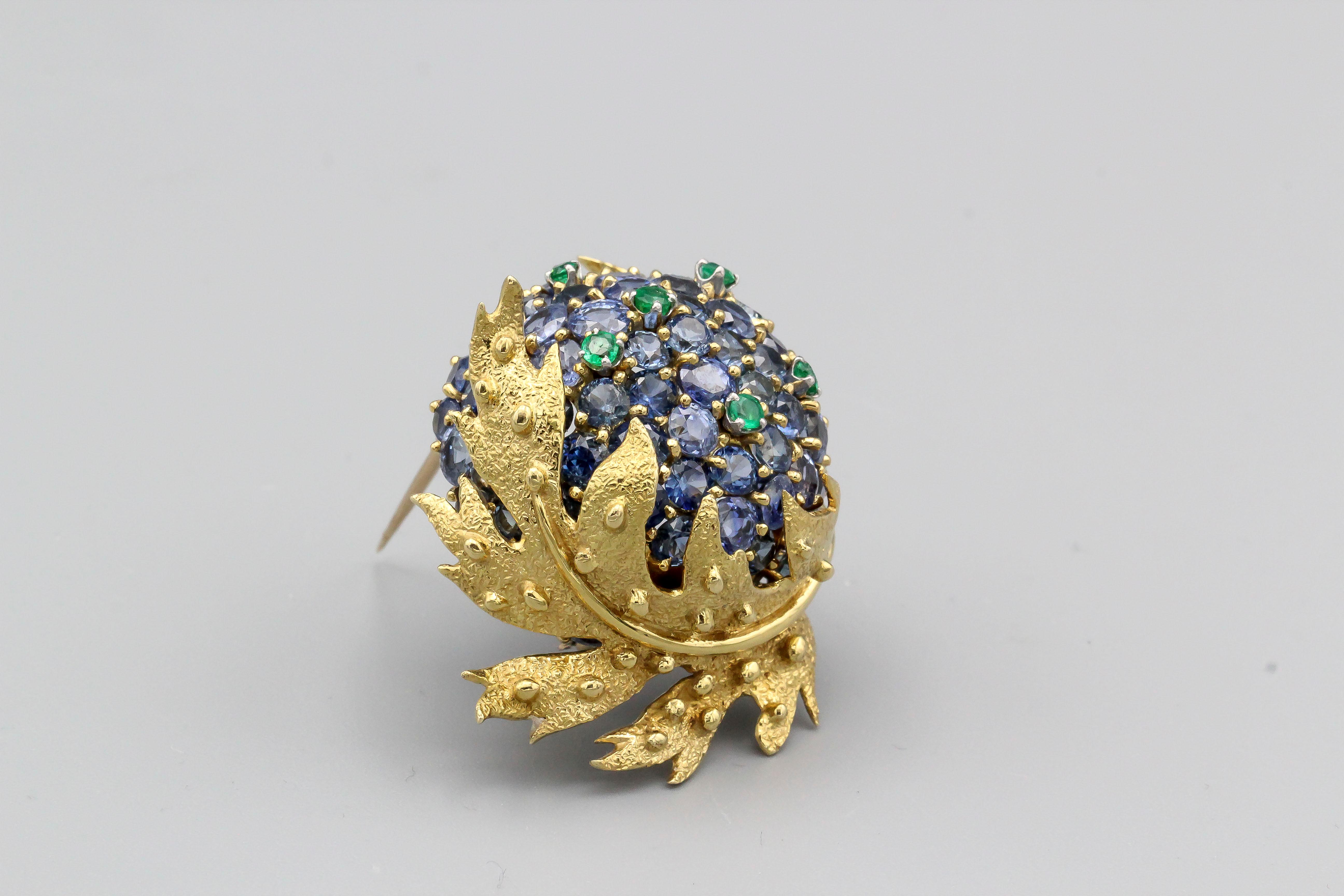 Very fine brooch by Tiffany & Co. Schlumberger, circa 1970s.  Made in 18k yellow gold with sapphires and emeralds, in the likeness of a chestnut.  A charming brooch full of life and whimsy, can be worn with versatility both day and