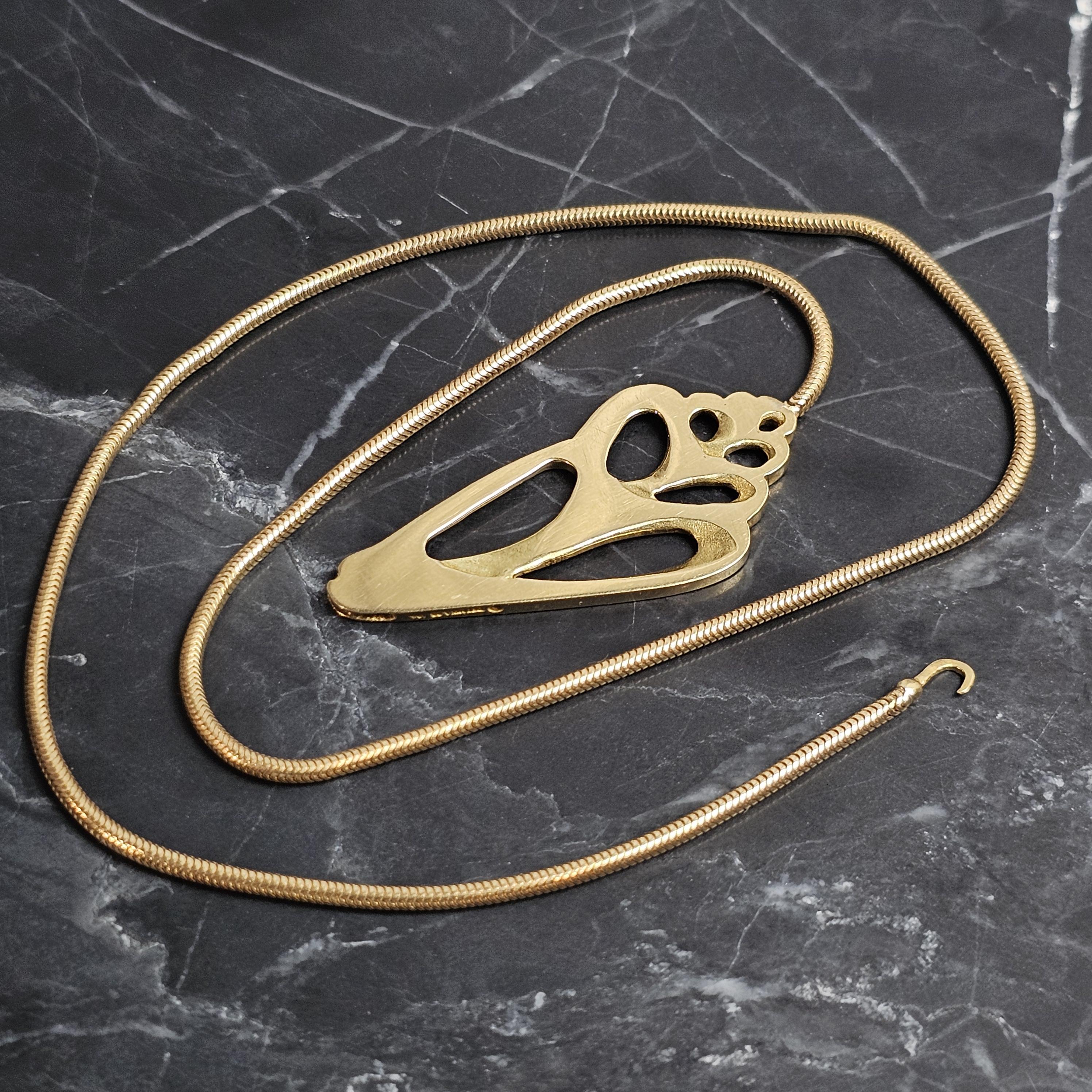 Este exclusivo collar gargantilla con colgante de concha marina de Tiffany & Co. es una pieza llamativa. Elaborado con precisión, presenta un diseño abstracto de colgante calado sobre una cadena de serpiente suave como la seda. El collar es una