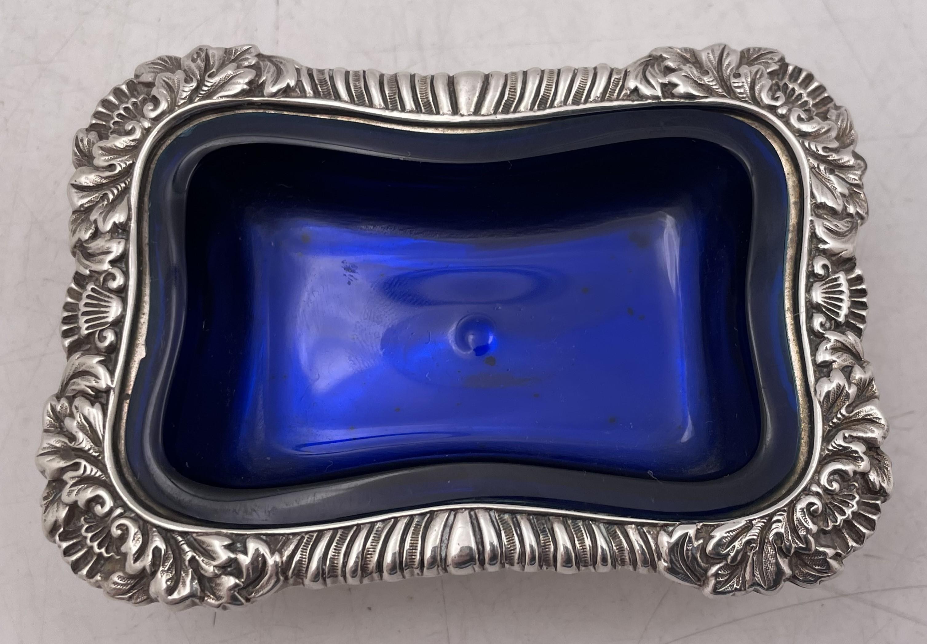 Tiffany & Co. set de 4 salières ouvertes en argent sterling avec doublures bleues amovibles, numéro de modèle 5438 de 1879. Magnifiquement ornés de motifs géométriques et floraux stylisés sur le pourtour, ils mesurent 3 2/3'' de largeur sur 2 1/2''