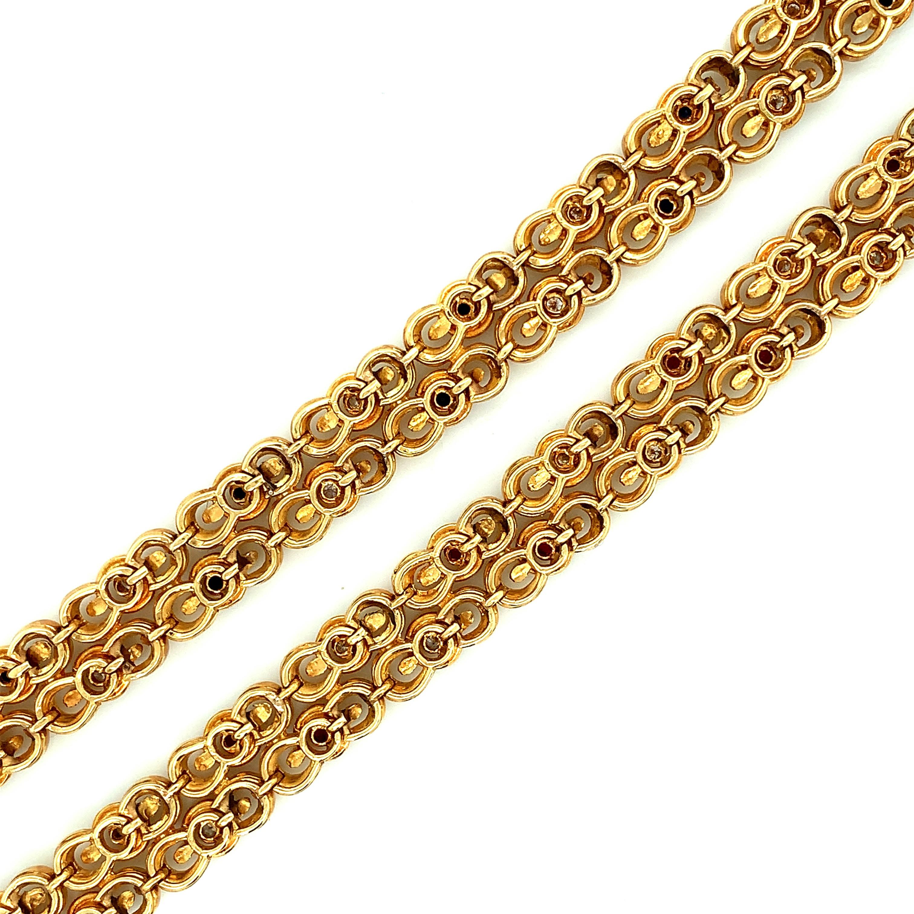 Tiffany & Co. set of two 18 karat yellow gold bracelets. One bracelet features sapphires and diamonds while the other has rubies and diamonds. Individually, they weigh 41.3 grams. Together, the total weight is 82.6 grams. Both measure a length of