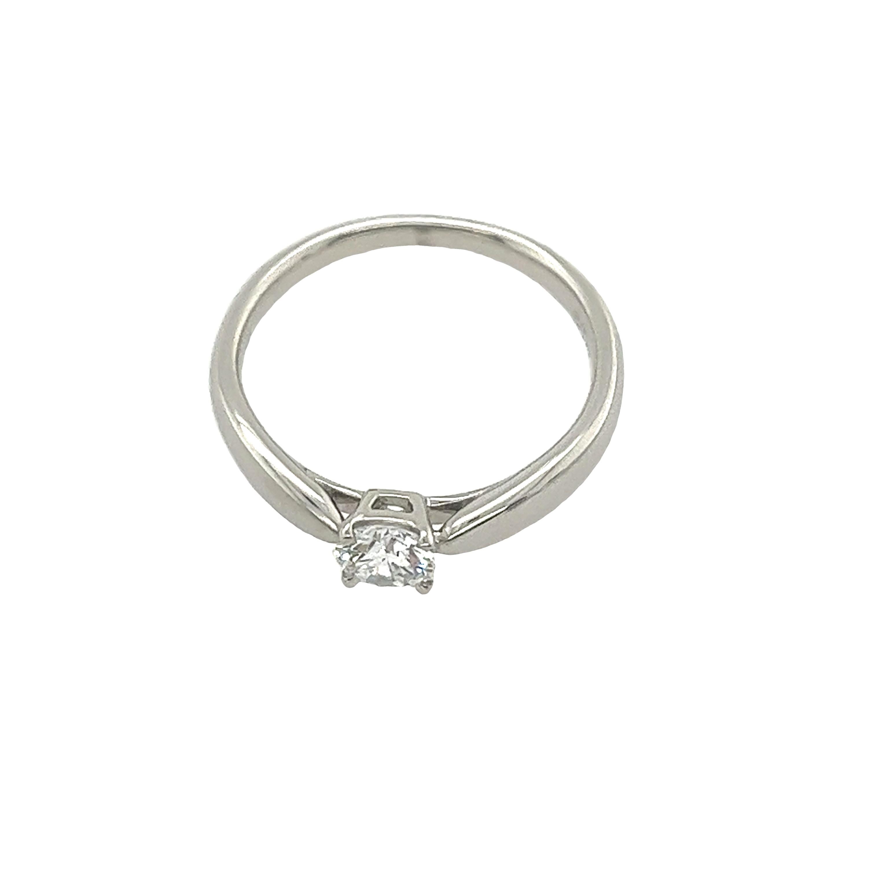 Exemplifying timeless elegance, the Tiffany & Co. Setting 0.29ct Diamond Solitaire Engagement Ring boasts a captivating E/VS1 diamond. With its classic design and impeccable clarity, it serves as a radiant symbol of everlasting love and