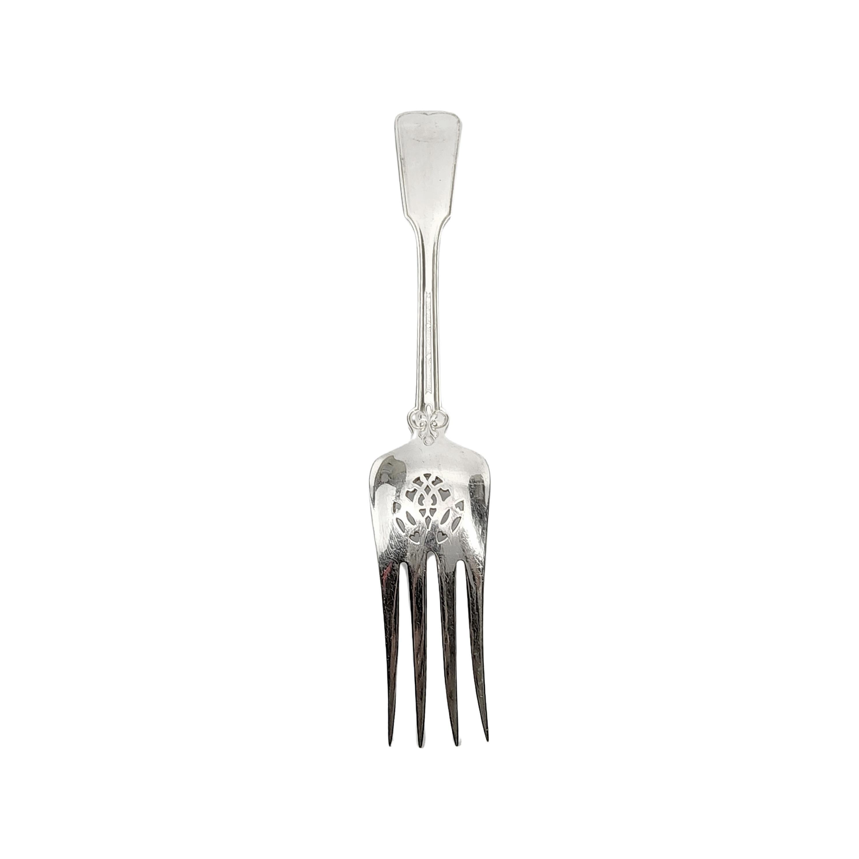 Sterling silver cold meat fork in the Shell & Thread pattern by Tiffany & Co with monogram.

Monogram appears to be C

The Shell & Thread pattern was introduced in 1905, and continues to be one of the most in-demand of Tiffany's classic patterns.