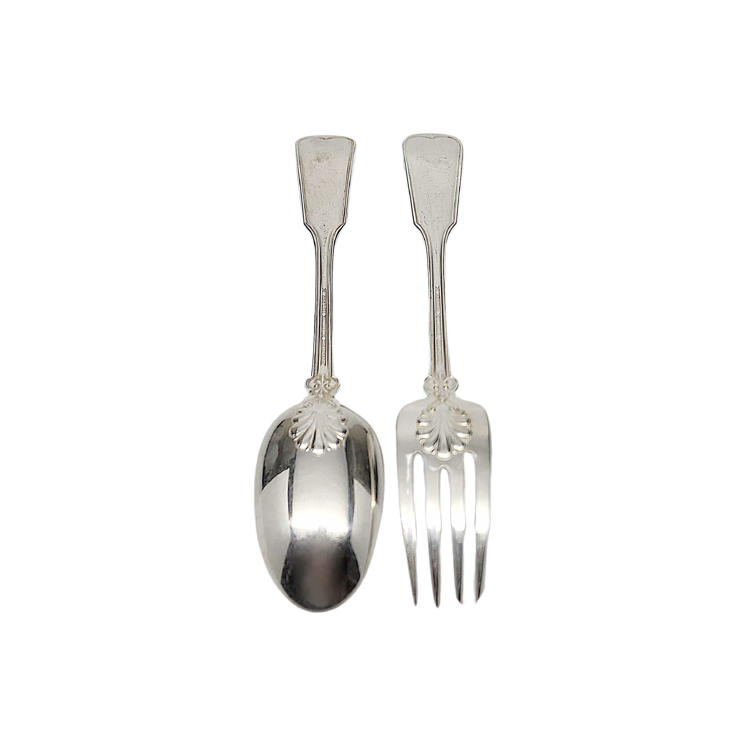 2 piece serving set including a sterling silver serving spoon and fork in the Shell & Thread pattern by Tiffany & Co with monogram.

Monogram appears to be C

The Shell & Thread pattern was introduced in 1905 and continues to be one of the most