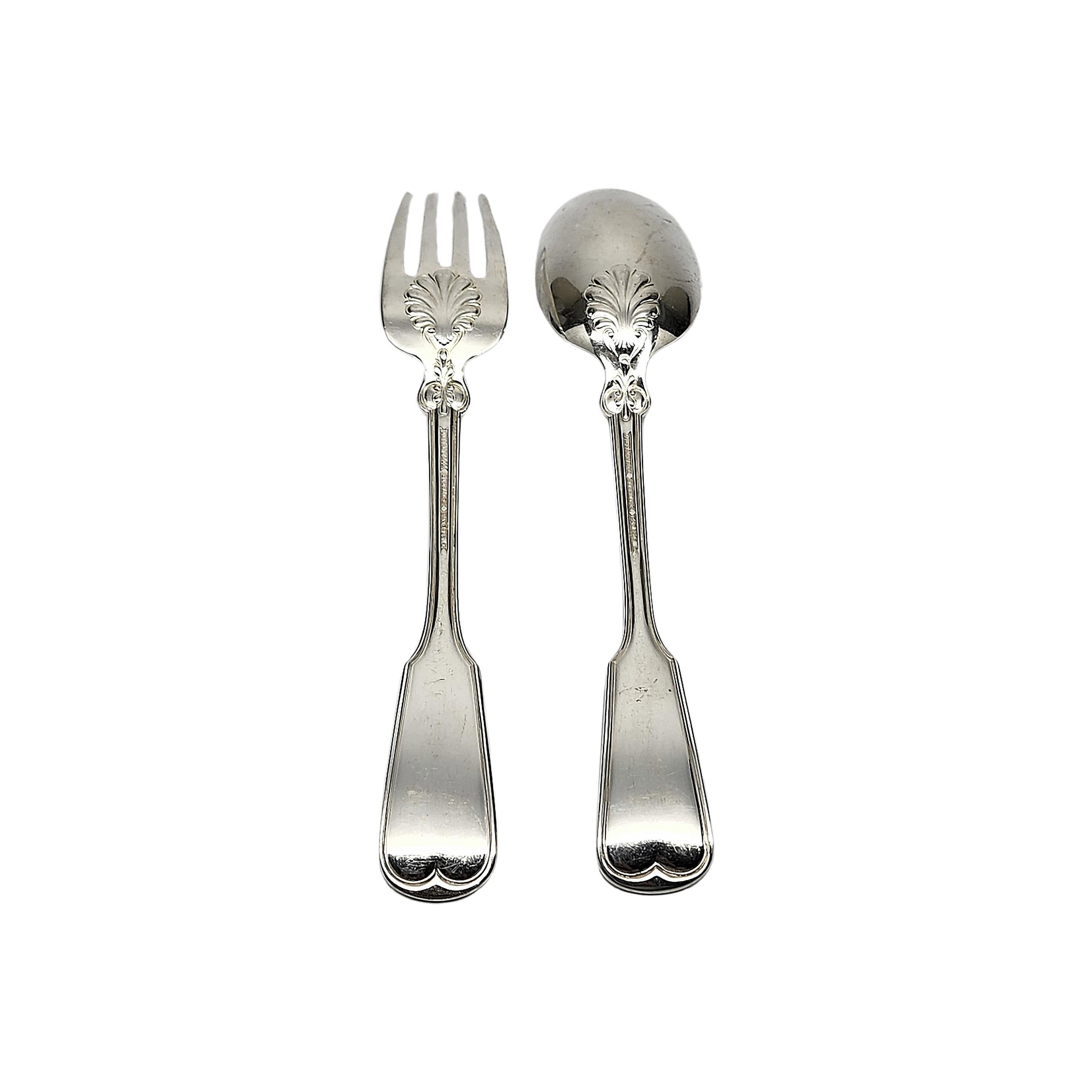 2 piece serving set including a sterling silver serving spoon and fork in the Shell & Thread pattern by Tiffany & Co with monogram.

Monogram appears to be C

The Shell & Thread pattern was introduced in 1905 and continues to be one of the most