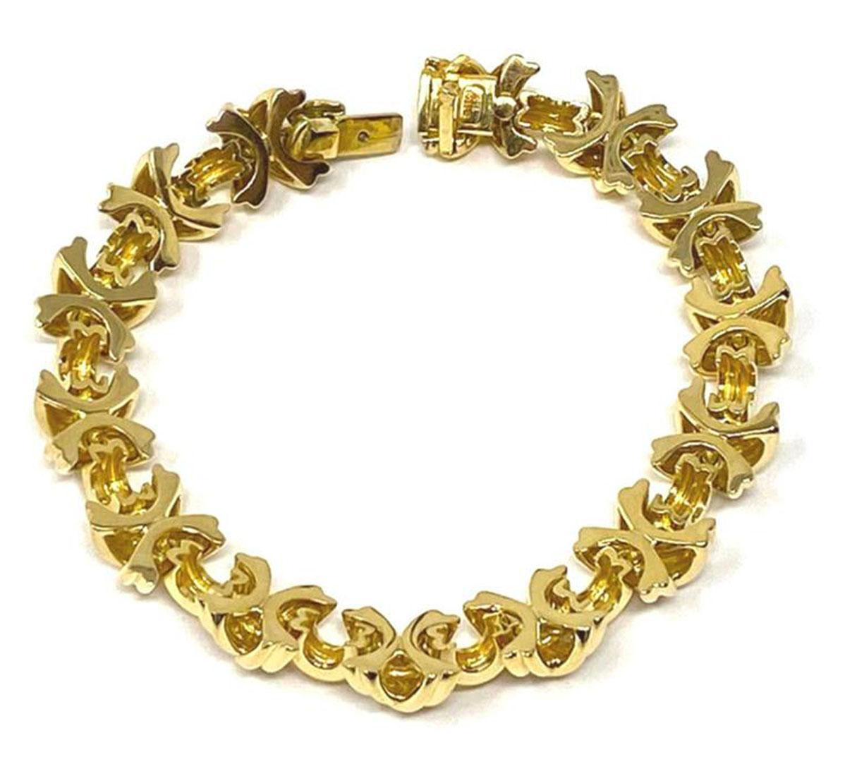 This is a gorgeous authentic bracelet by Tiffany & Co. from the Signature X link collection. It is crafted from 18k yellow gold with a polished finish. The grooved X links are joined together with small curved bar and it secures with a push in clasp