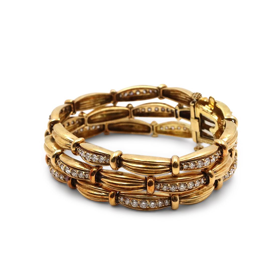 Authentic classic 3-row bracelet from the 'Tiffany Signature Series' crafted in 18 karat yellow gold. Designed in the form of alternating reeded links set with round brilliant cut diamonds (E-F color, VS clarity) for an estimated 5 carats total
