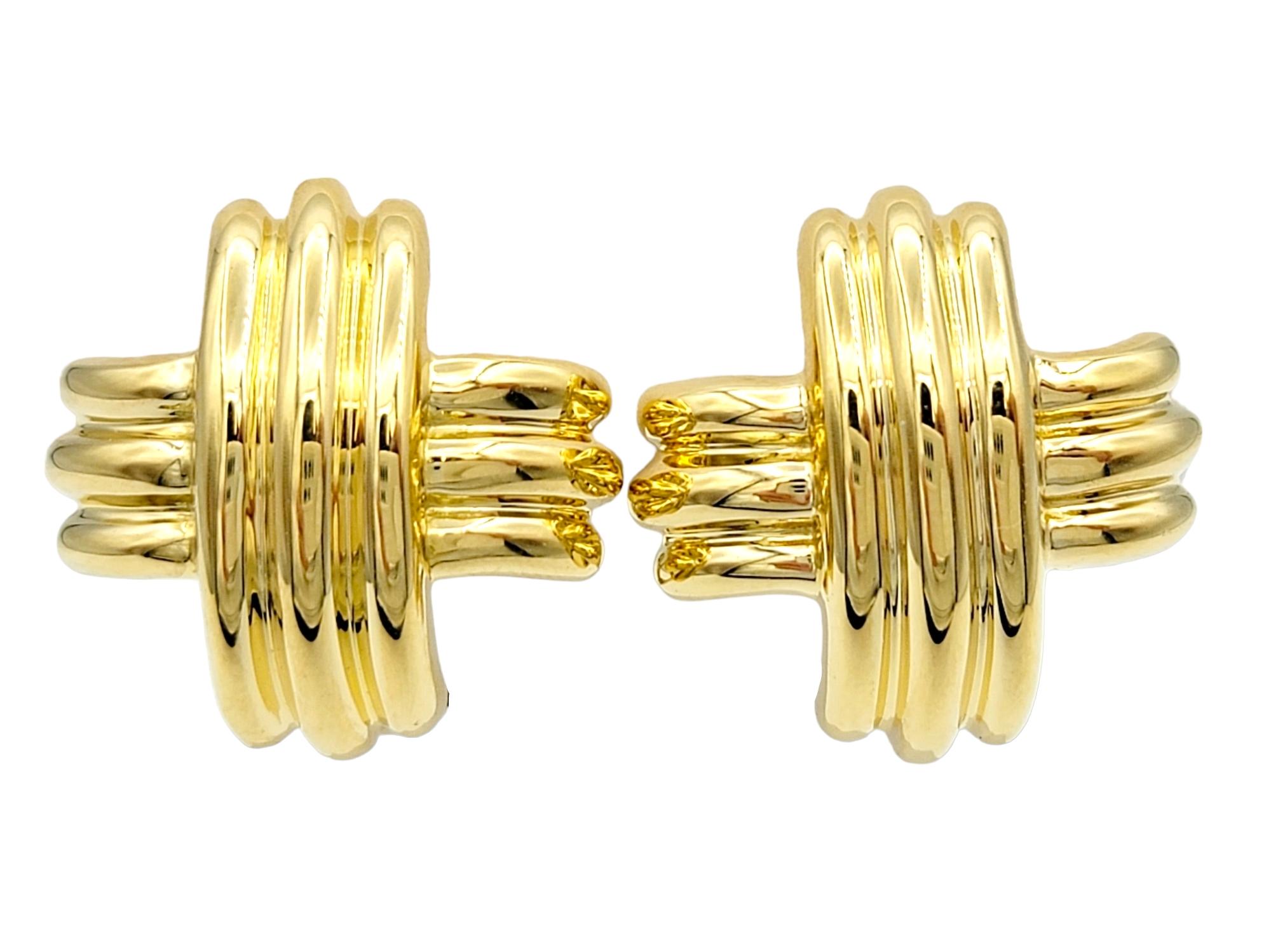 Indulge in the iconic elegance of these Tiffany & Co. gold earrings, a dazzling expression of timeless sophistication crafted in lustrous 18 karat yellow gold. The signature 'X' design, where two ridged pieces elegantly overlap perpendicularly,