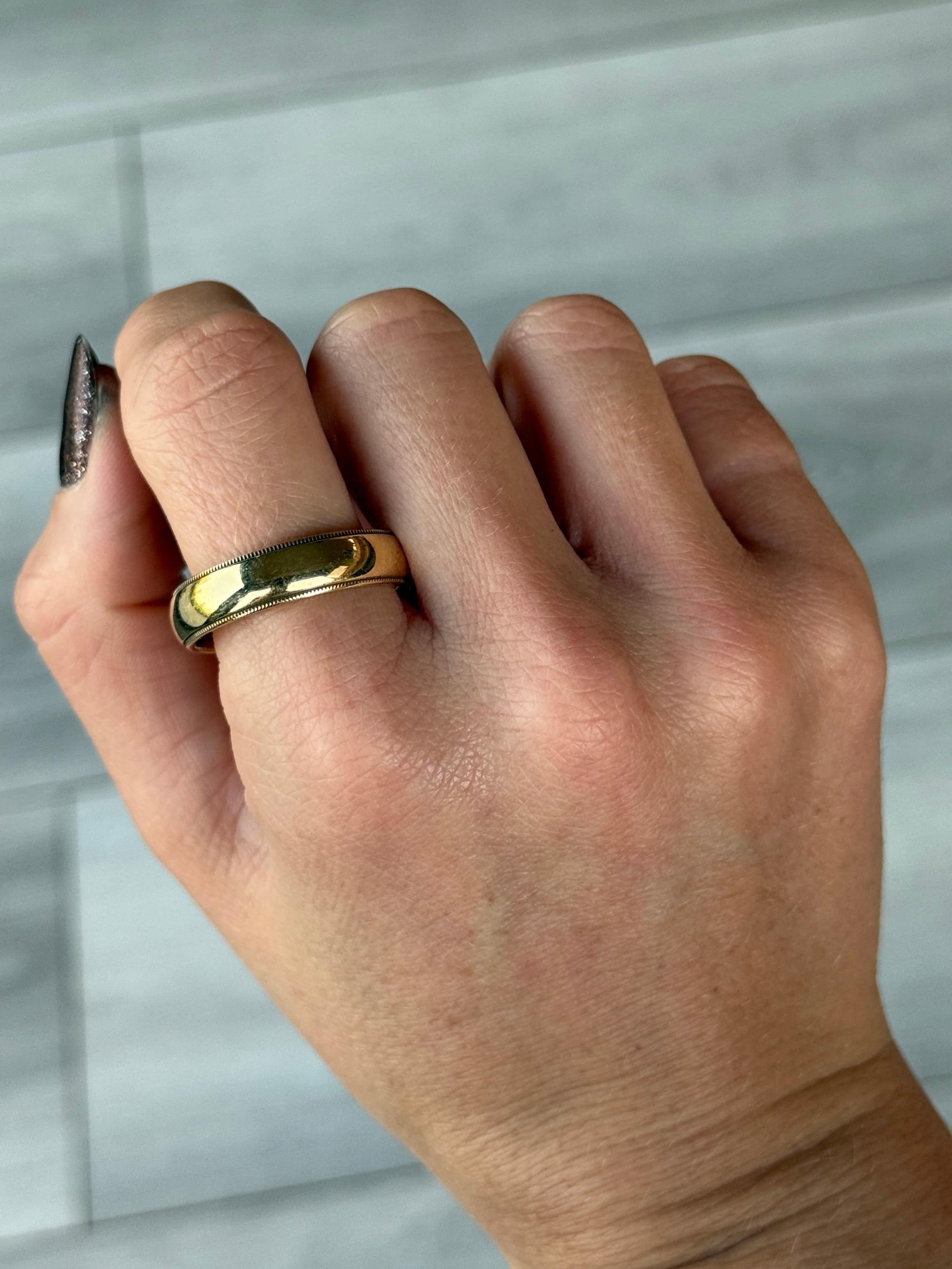 Ce magnifique bracelet Tiffany & Co en or jaune 18 carats présente un motif milgrain classique et la signature est gravée sur la bande intérieure. Ces détails s'harmonisent parfaitement avec l'or magnifiquement brillant. 

Taille de l'anneau : Y ou