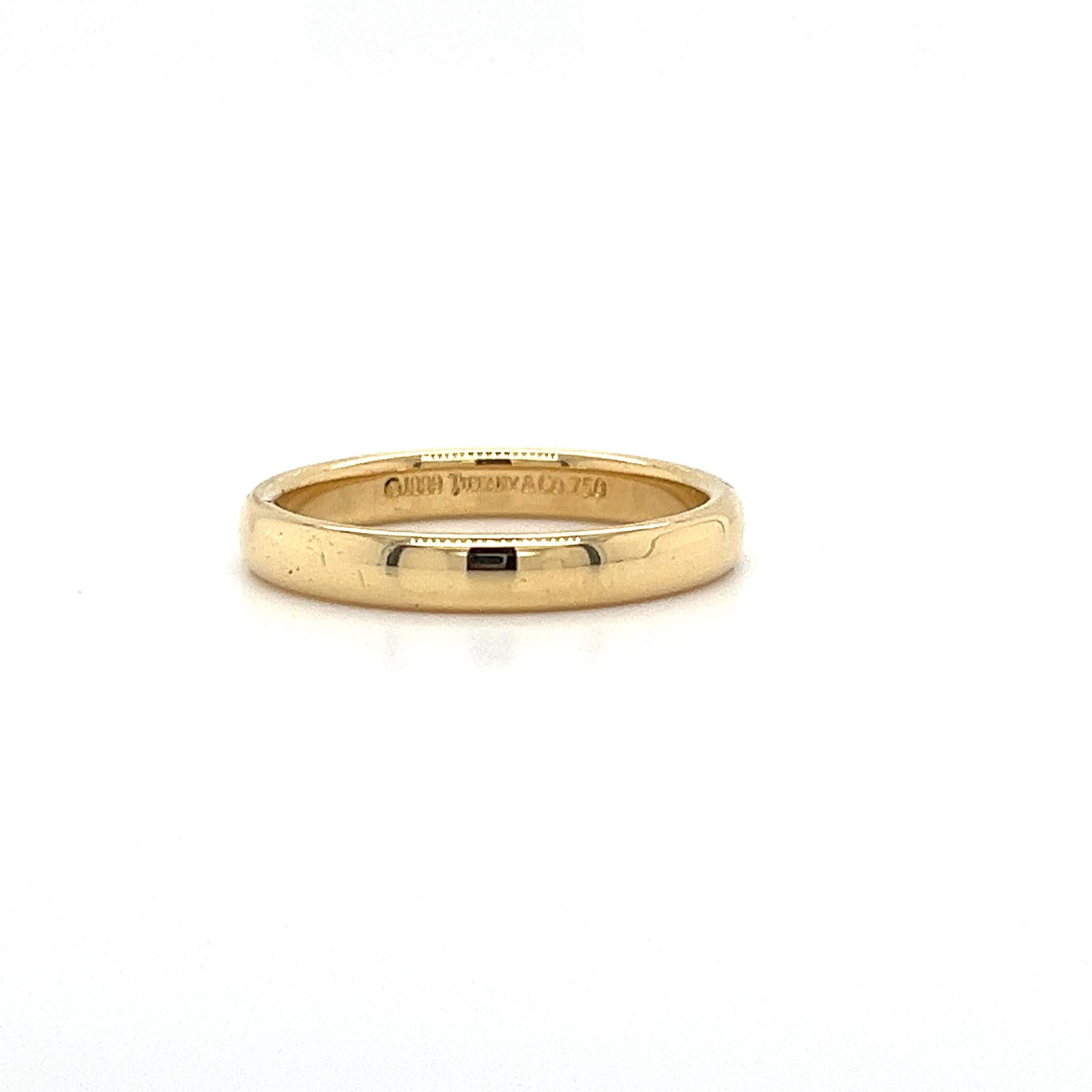 Tiffany & Co. signed 18 karat solid yellow gold wedding band ring. A simple, lasting message of commitment and love. Made better by legendary New York jeweler, Tiffany and Company. At 3mm, this wedding band is a sleek ring option with just the right