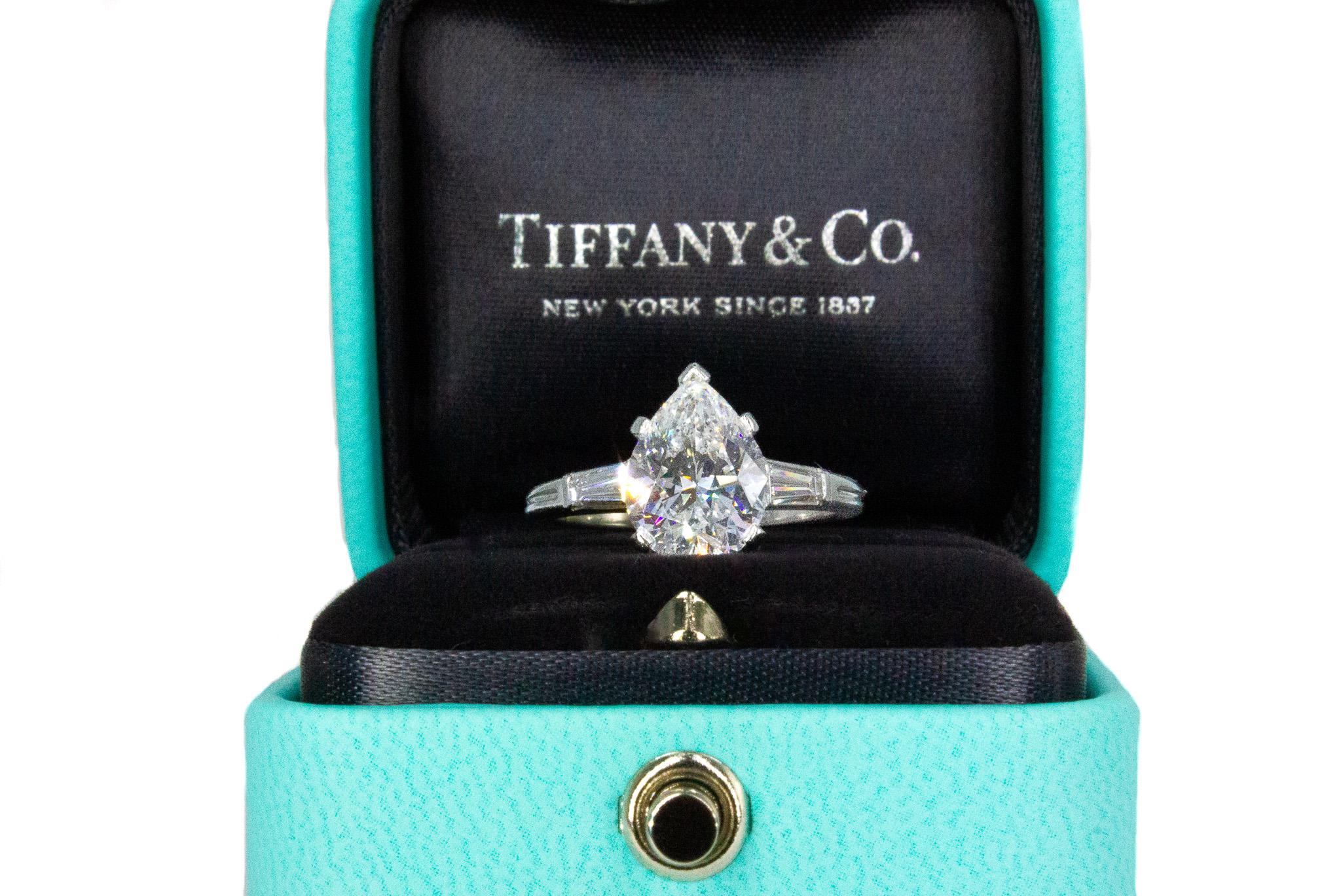 Celebrate love with this stunning Tiffany & Co. Signed Pear Shaped Diamond Engagement Ring, a true symbol of timeless elegance. This exquisite piece features a 2.58 carat pear-shaped center diamond, GIA certified with F color and VS2 clarity,