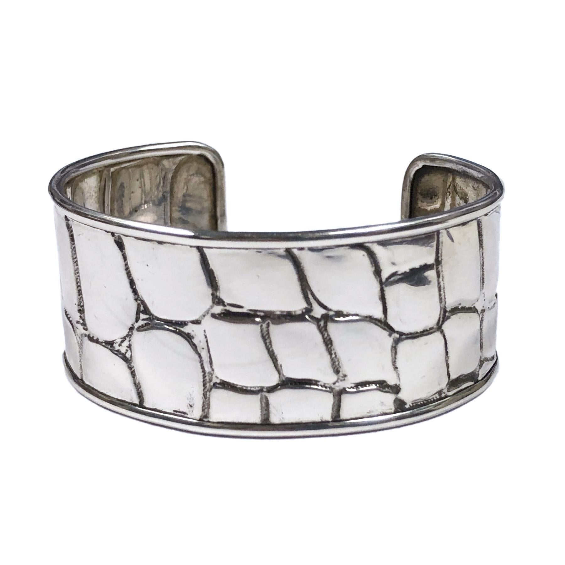 Circa 1990 Tiffany & Company Sterling Silver Cuff Bracelet with a textured Alligator pattern. measuring 1 inch wide an opening of 1 1/8 inch and a wrist measurement of 6 3/4 inches.