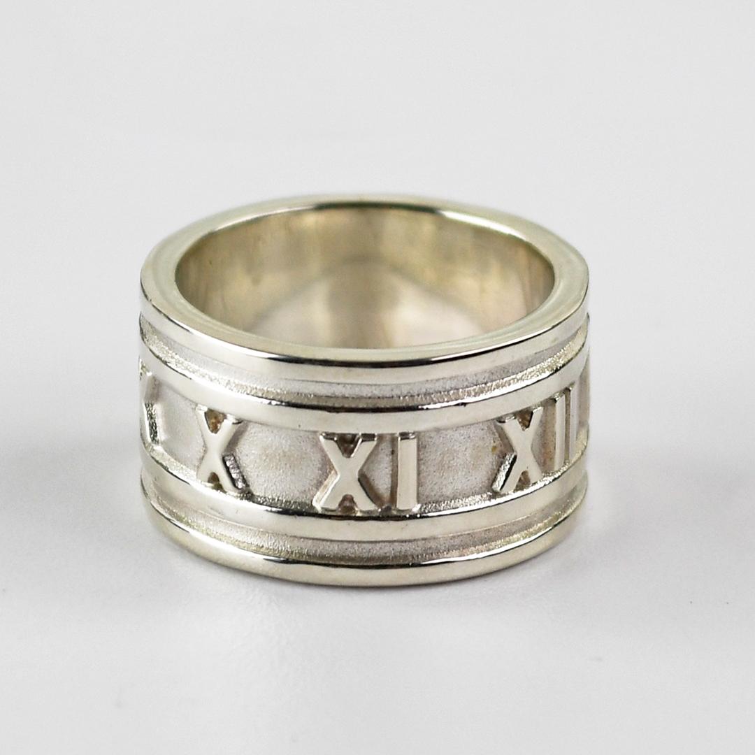 Ladies Tiffany & Co silver Atlas, Roman numeral band ring.
Stamped Tiffany & Co, @1995,  925 and weighs 11 grams.
The band measures 11.5mm wide.
Ring size is 6. Looks almost new condition.
No original box or bag.