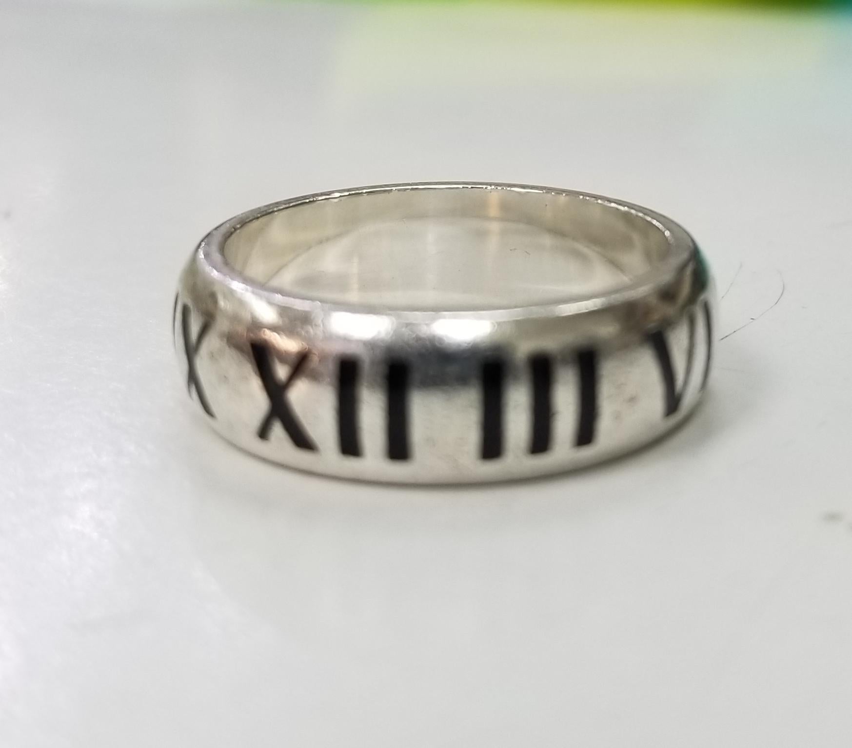 Authentic Tiffany & Co. ring
Hallmark: Pictured.
100% authentic!
Comes with the Tiffany pouch!
TIFFANY & Co.  ATLAS STERLING SILVER WEDDING BAND RING SIZE 12.5
    Ring size is a 12.5
    Ring measures 8 mm wide
    Sterling silver, Enamel Roman