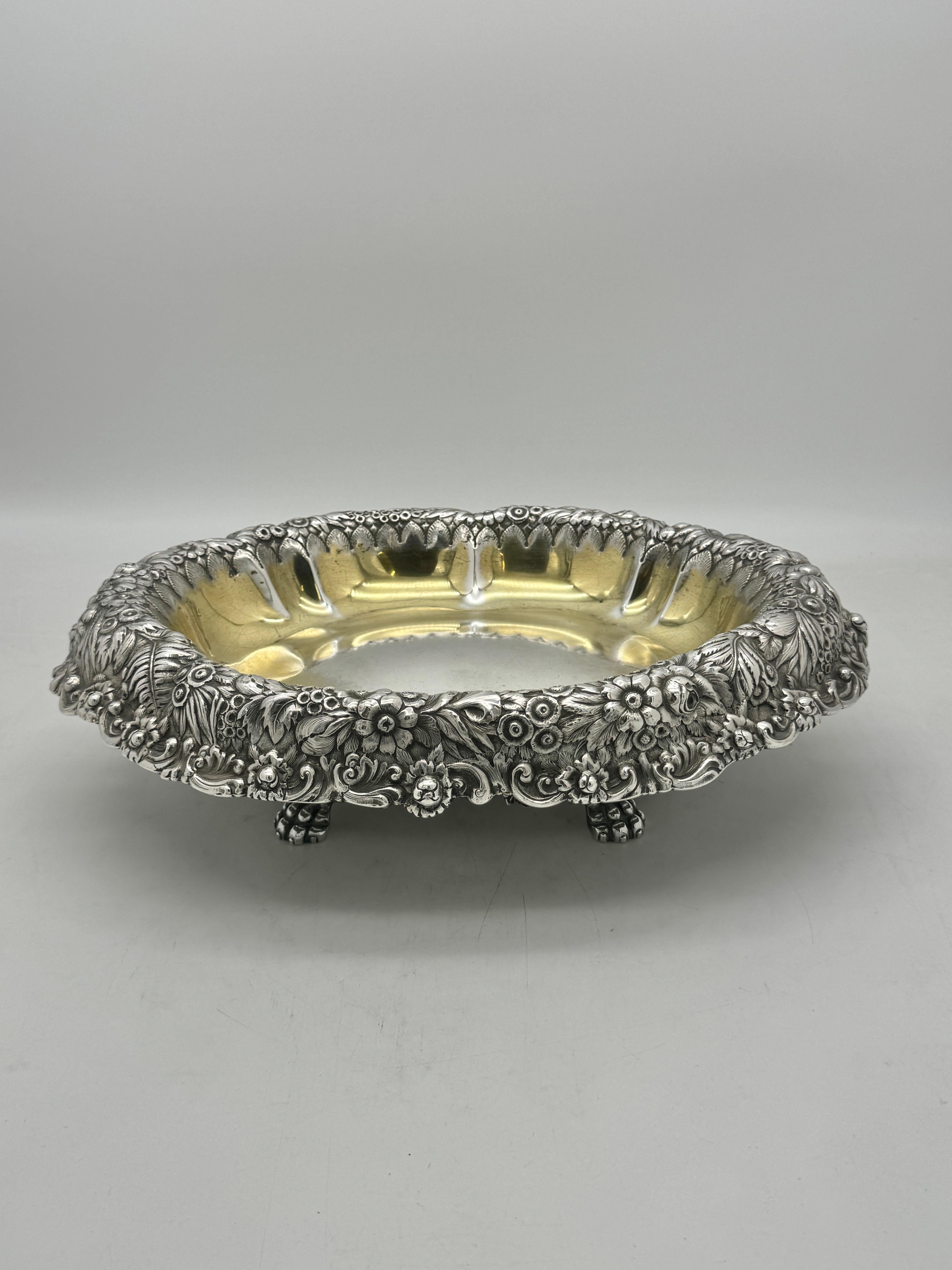 Tiffany & Co. Cuenco centro de mesa de plata de ley, ovalado sobre cuatro patas y con el borde decorado con hojas y flores de helecho.
El interior conserva parte del dorado original, lo que le confiere un maravilloso aspecto cálido.
Las marcas que
