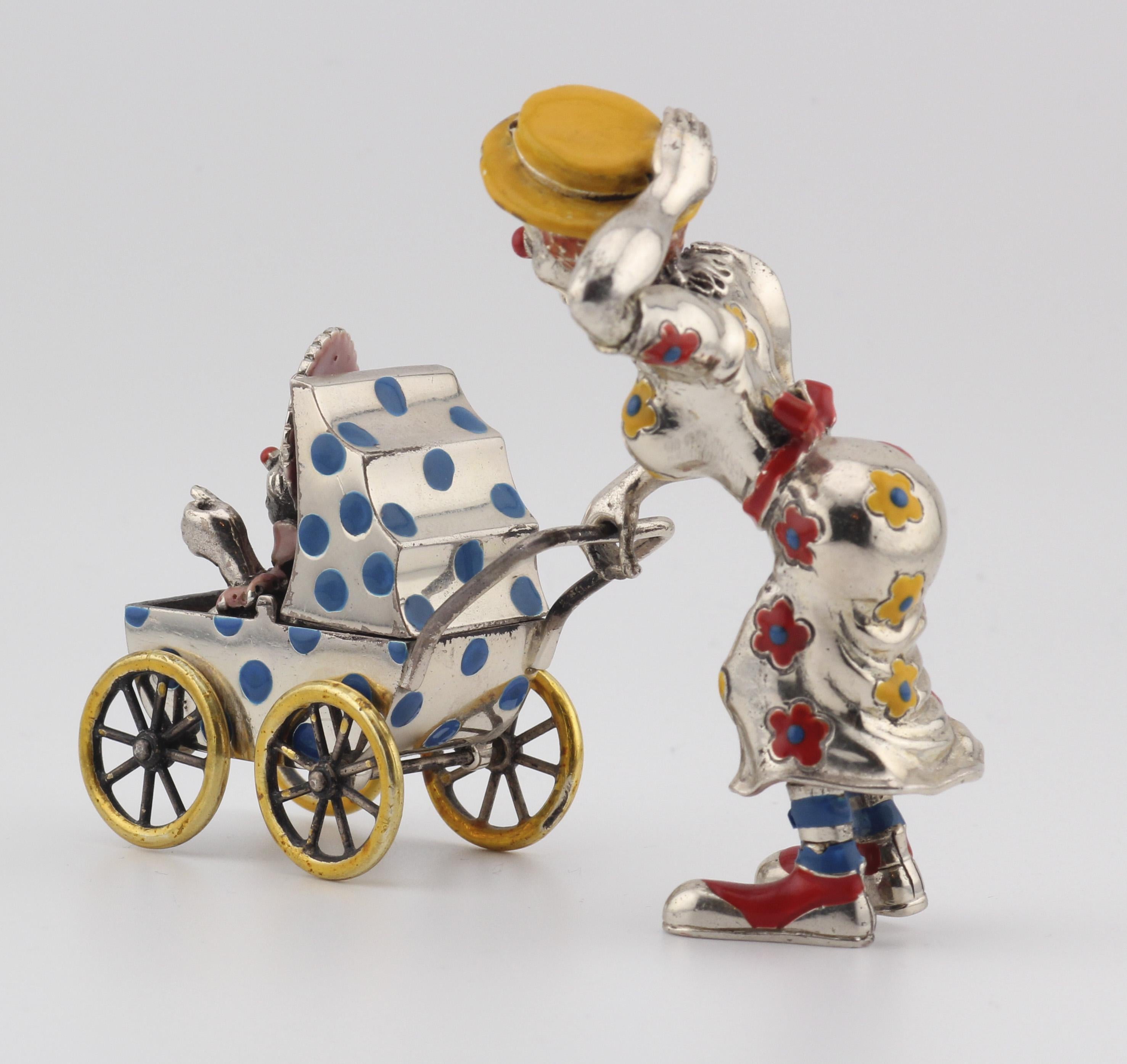Treten Sie ein in die bezaubernde Welt der Launenhaftigkeit und Handwerkskunst mit dieser Tiffany & Co. Silber & Emaille Zirkus Clown Mutter & Baby in Kutsche Figurine. Diese sorgfältig gefertigte Figur ist ein Beweis für das Vermächtnis von Tiffany
