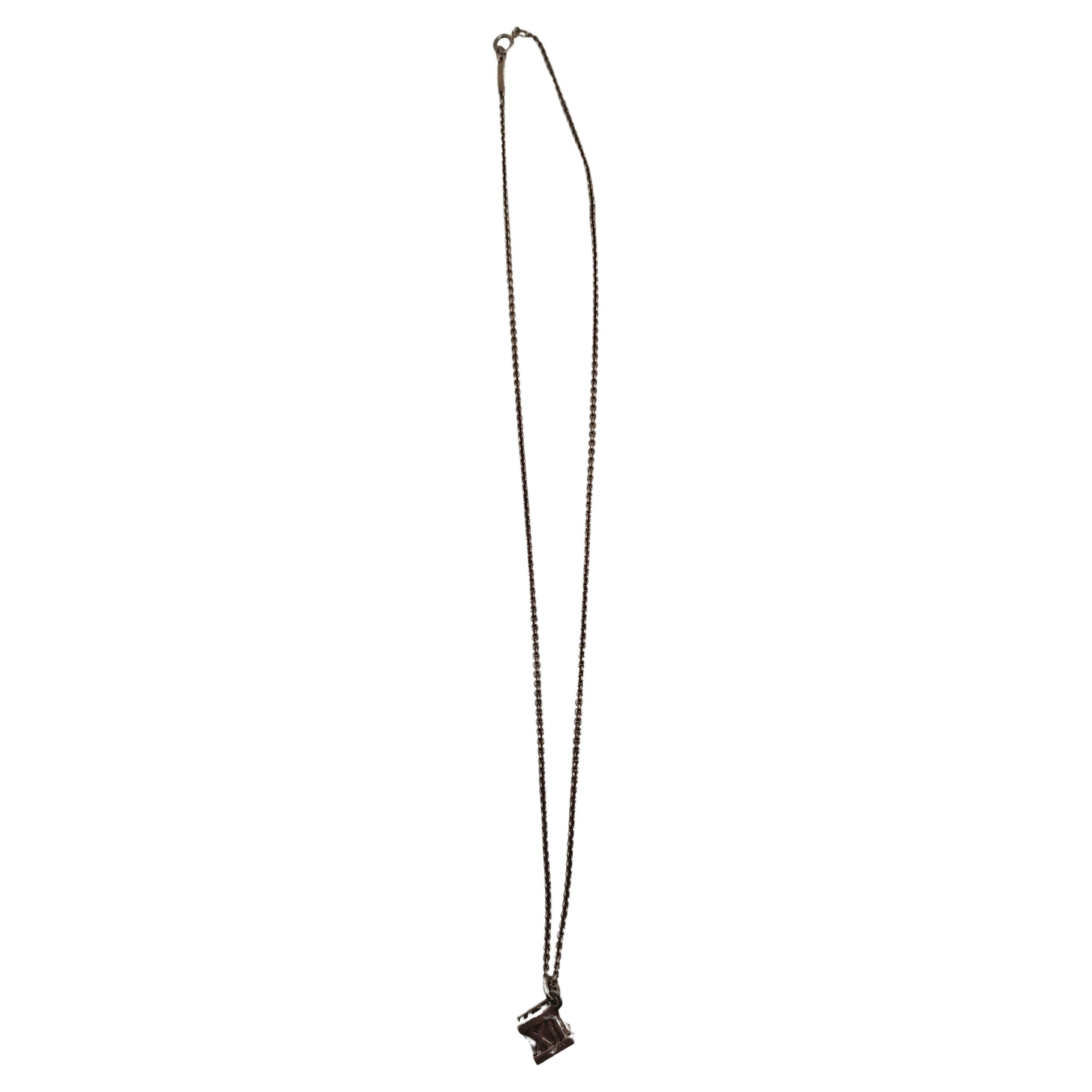 Embrace the elegance of Tiffany & Co. with this exquisite Silver Roman Numeral Cube Necklace. Featuring a delicate cube pendant engraved with classic Roman numerals, this piece captures the essence of timeless design and refined